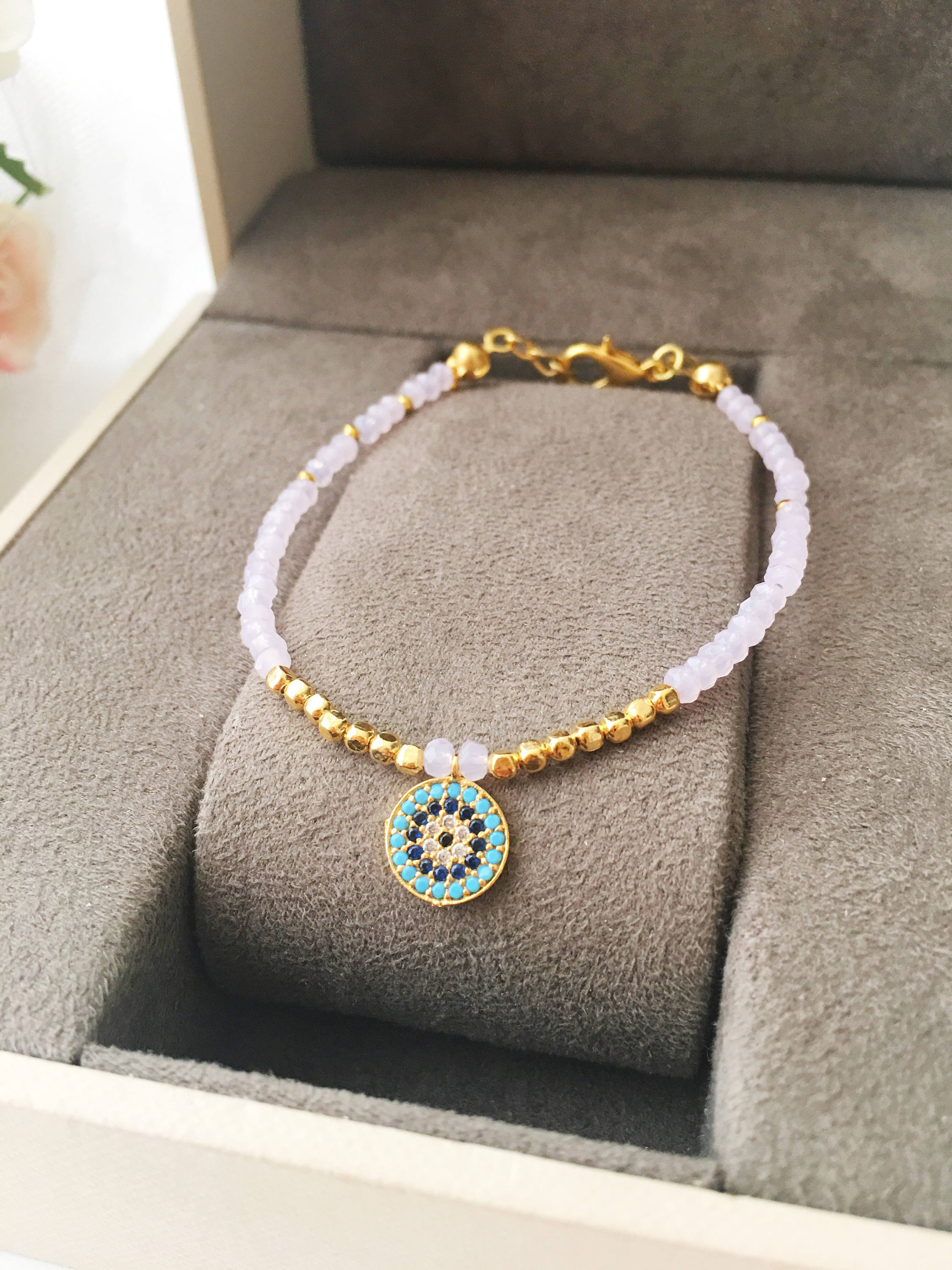 Handmade Evil Eye Bracelet featuring pink seed beads and zirconia charm, symbolizing luck and protection.