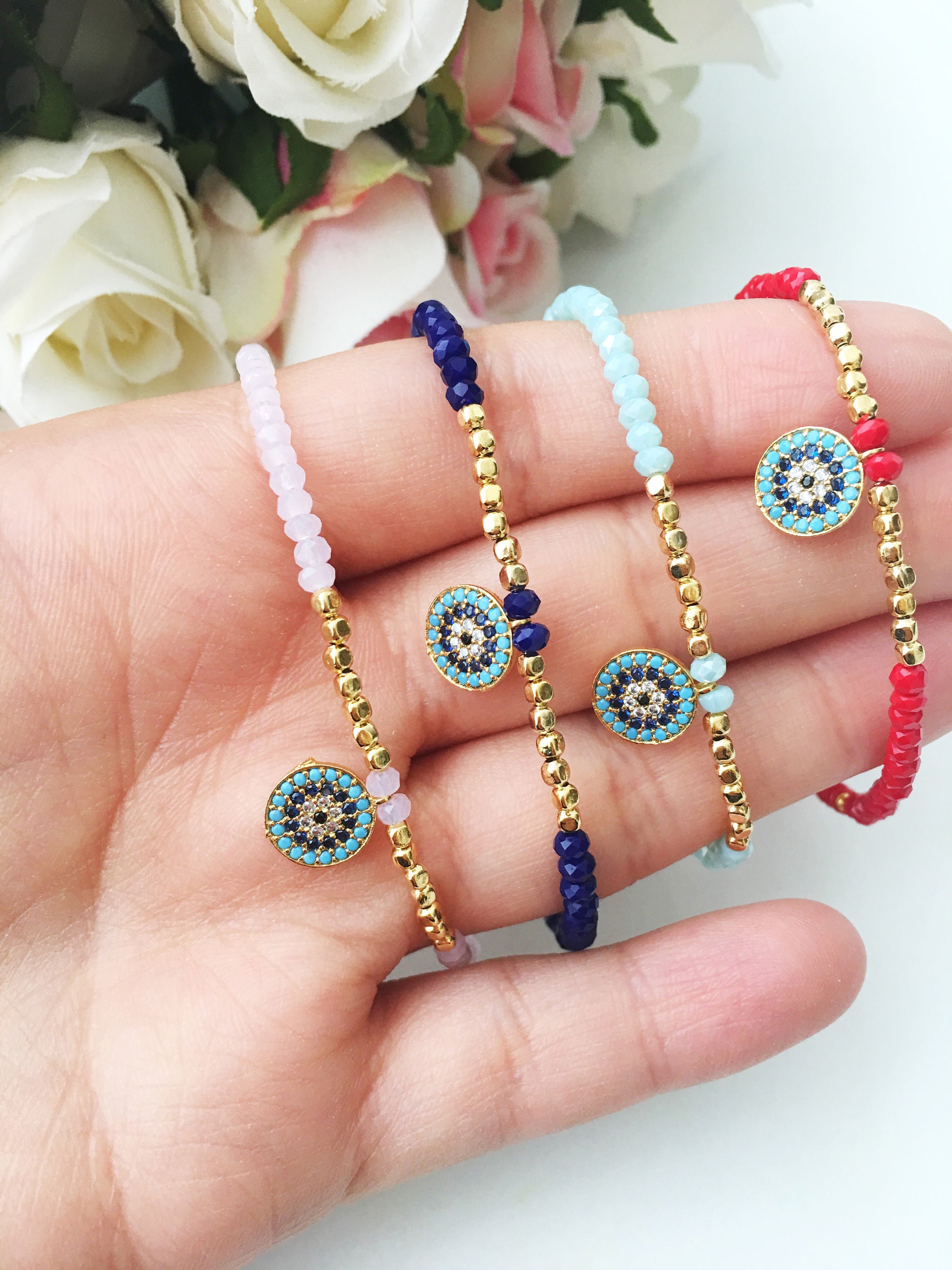 Handmade Evil Eye Bracelet featuring pink seed beads and zirconia charm, symbolizing luck and protection.