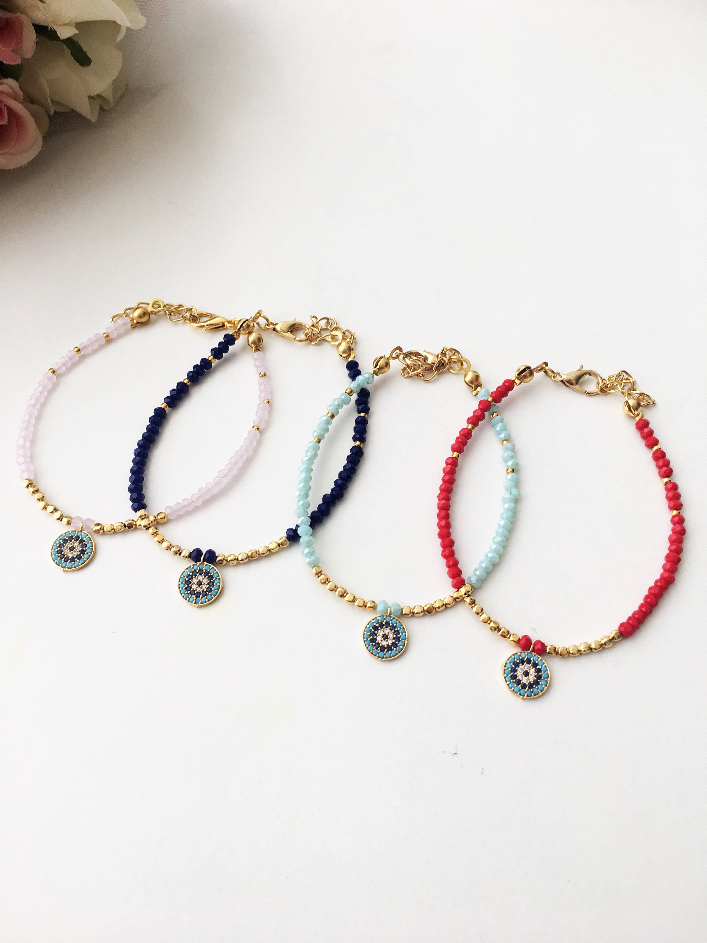 Handmade Evil Eye Bracelet featuring pink seed beads and zirconia charm, symbolizing luck and protection.