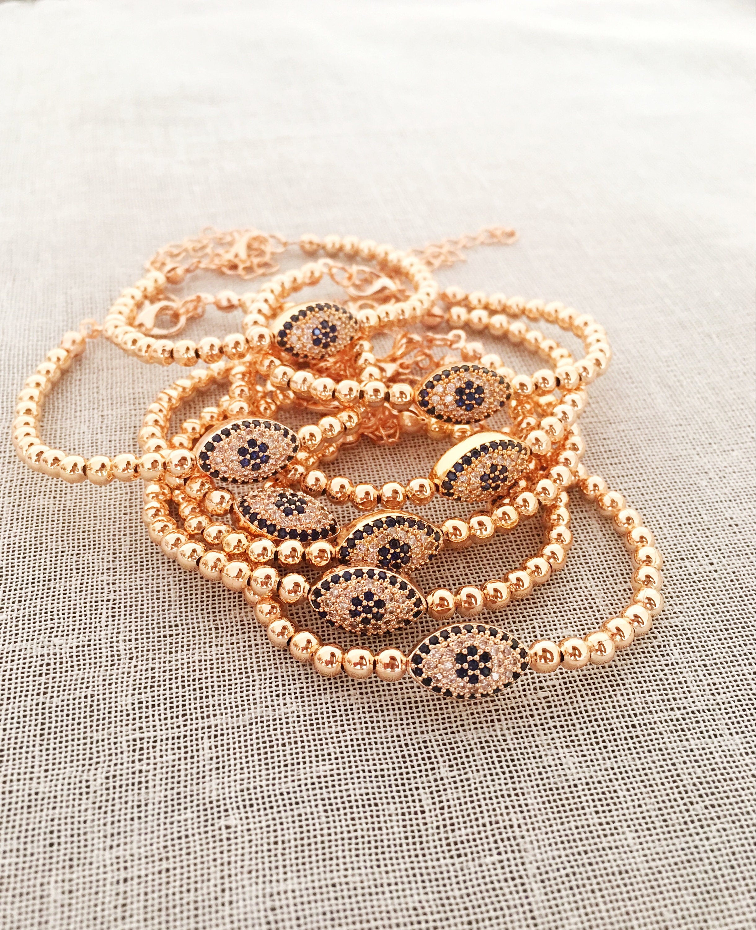 Elegant Evil Eye Bracelet featuring rose gold beads and adjustable design, made from tarnish-resistant 316L stainless steel.