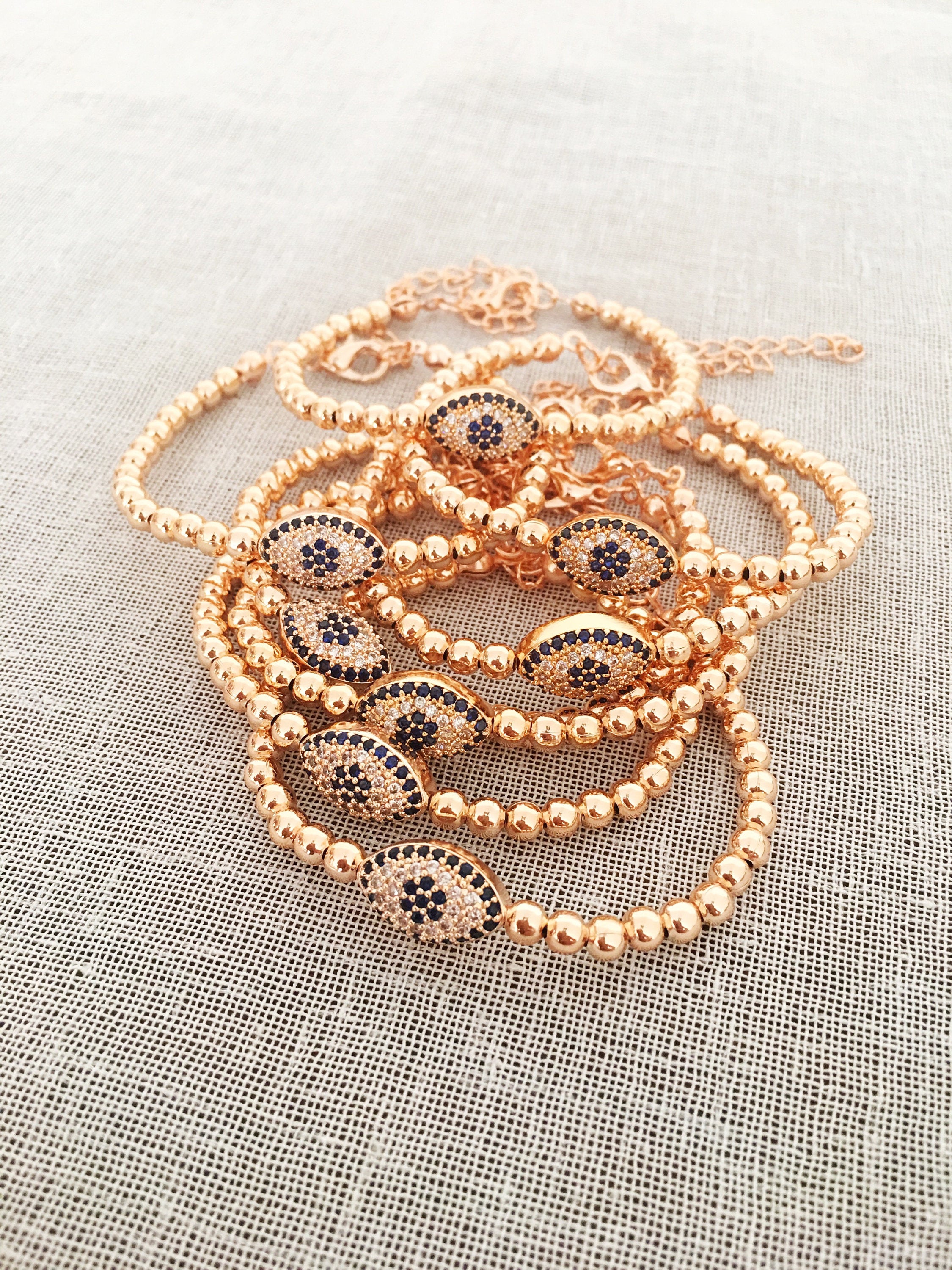 Elegant Evil Eye Bracelet featuring rose gold beads and adjustable design, made from tarnish-resistant 316L stainless steel.