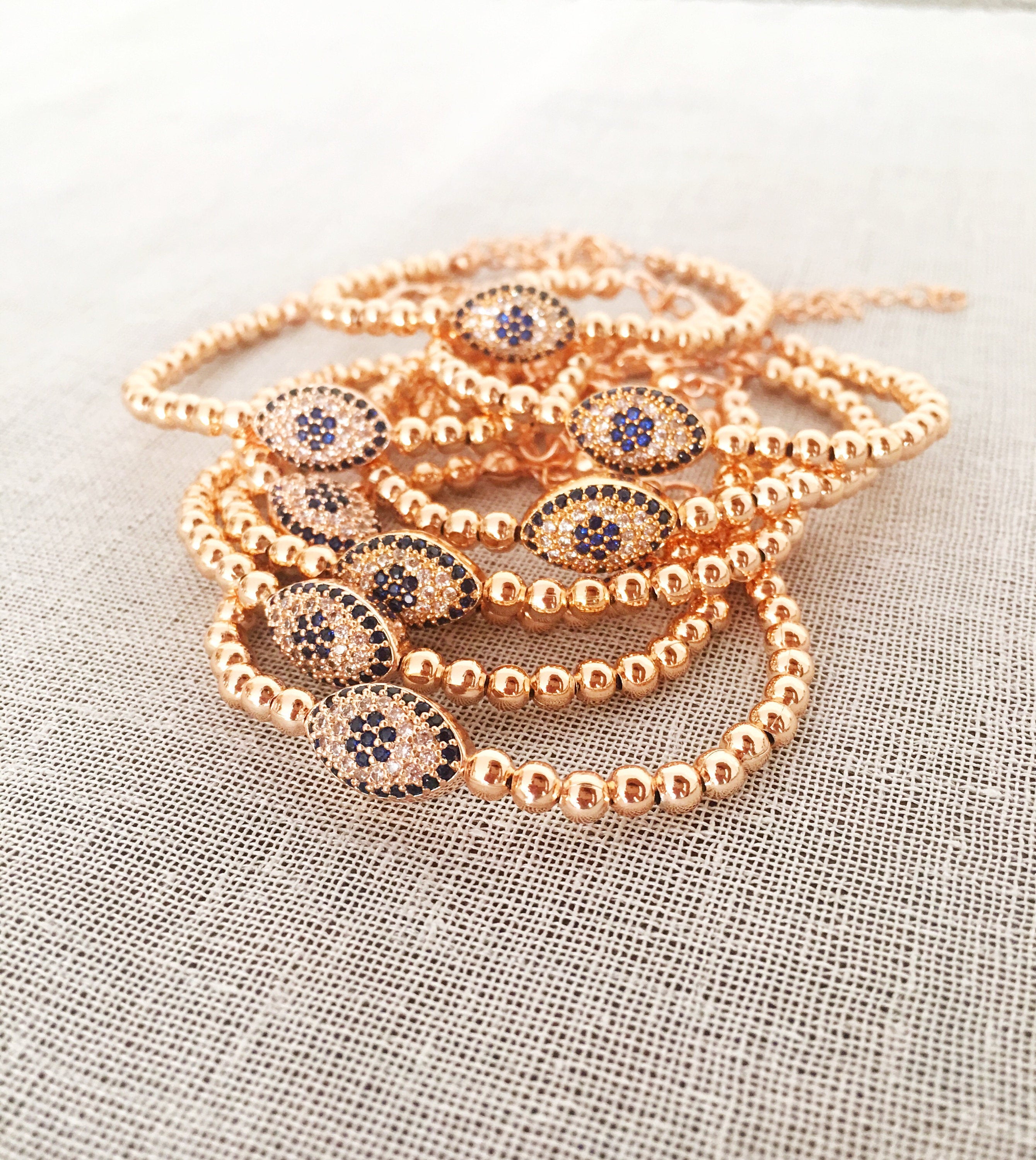 Elegant Evil Eye Bracelet featuring rose gold beads and adjustable design, made from tarnish-resistant 316L stainless steel.