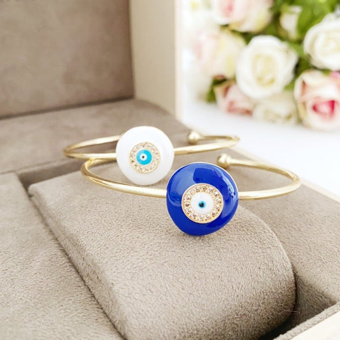 Elegant Evil Eye Bracelet featuring a movable oval charm on a round bangle, available in white and blue colors, made of tarnish-resistant stainless steel.