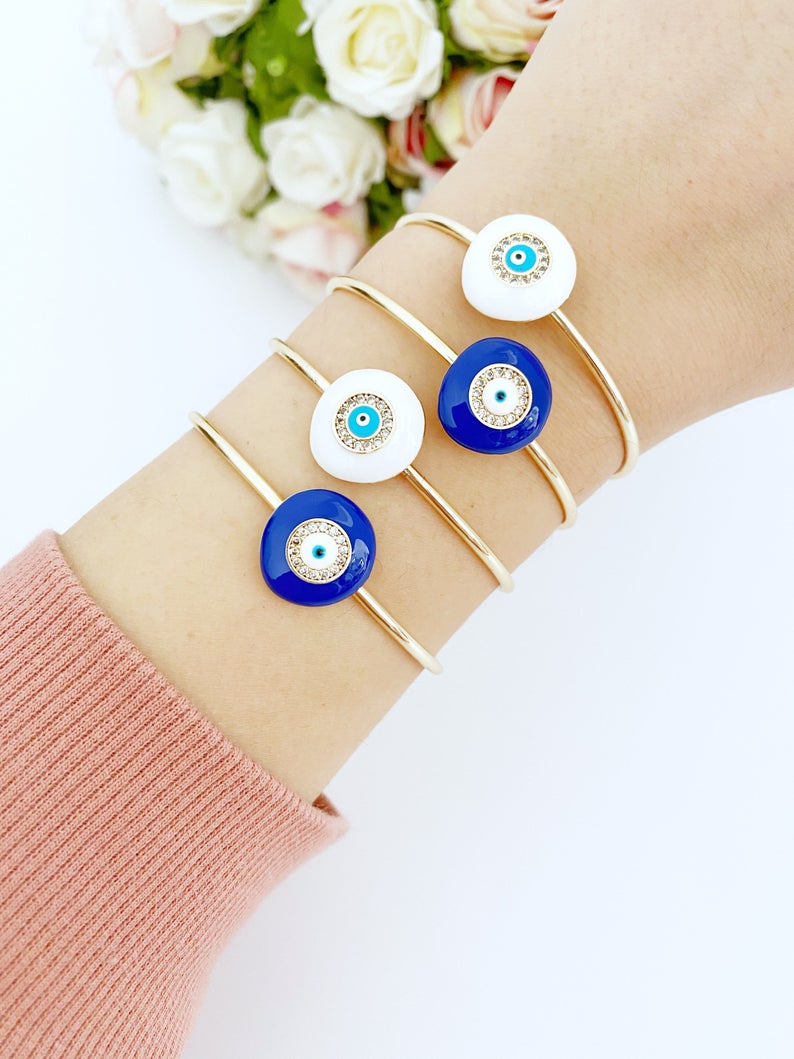 Elegant Evil Eye Bracelet featuring a movable oval charm on a round bangle, available in white and blue colors, made of tarnish-resistant stainless steel.