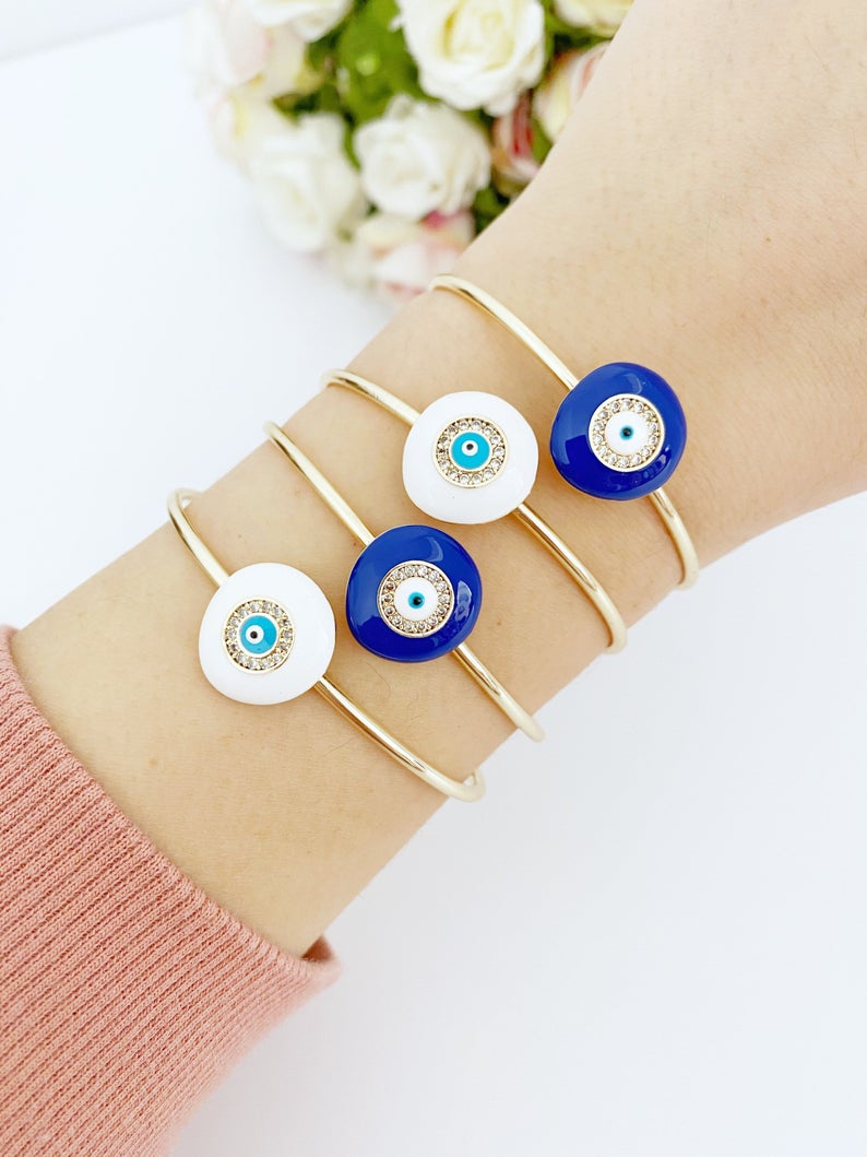 Elegant Evil Eye Bracelet featuring a movable oval charm on a round bangle, available in white and blue colors, made of tarnish-resistant stainless steel.