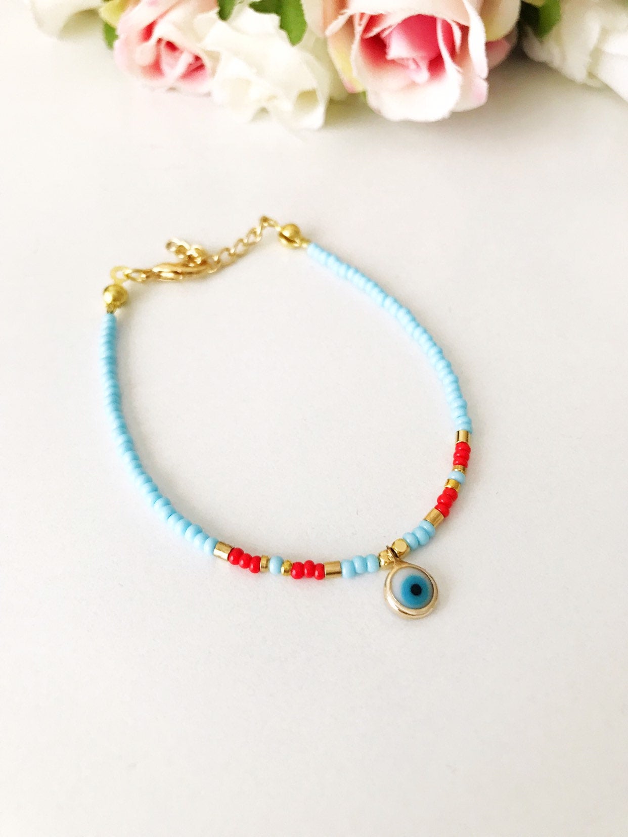 Handmade Evil Eye Bracelet featuring Miyuki seed beads in blue, turquoise, and white colors with an evil eye charm.