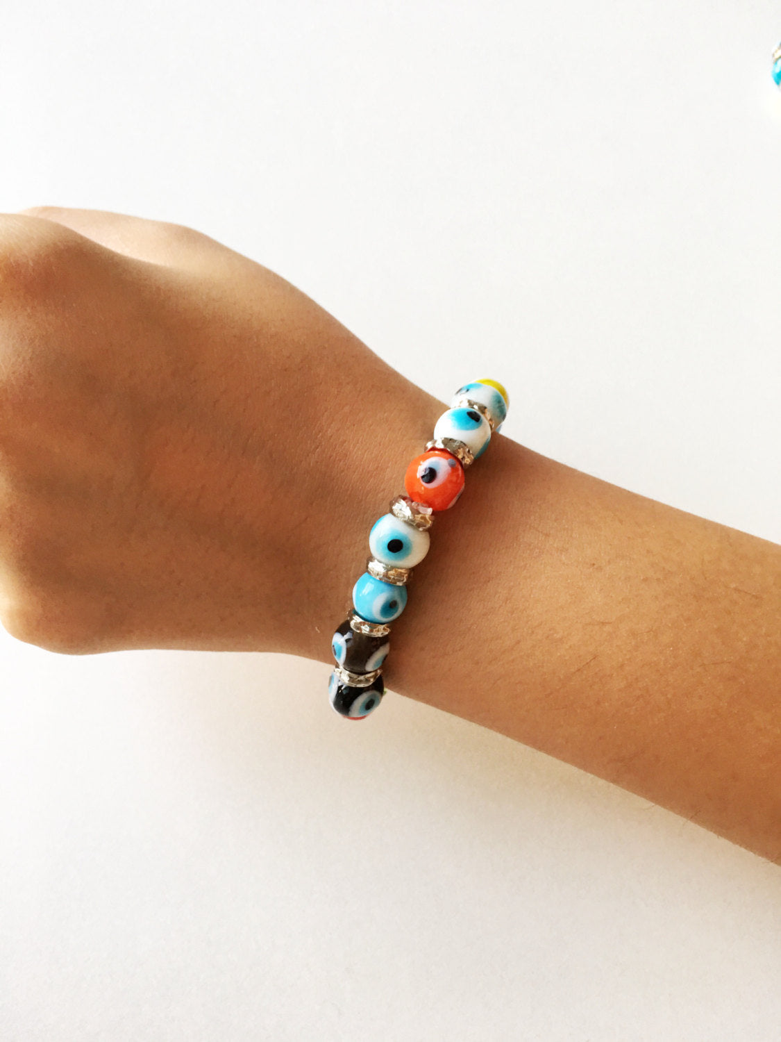 Colorful stretchable Evil Eye bracelet featuring a glass charm, symbolizing protection and good luck.