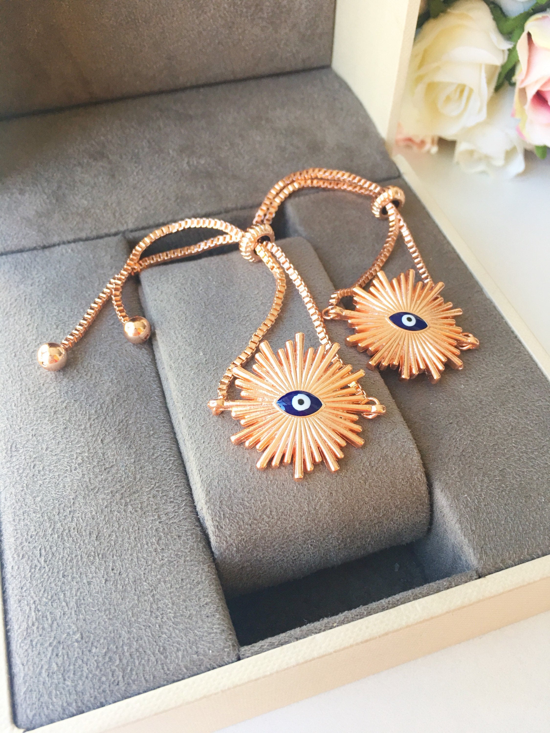 Sunny Charm Evil Eye Bracelet in gold and rose gold, featuring an evil eye charm and adjustable stainless steel chain.