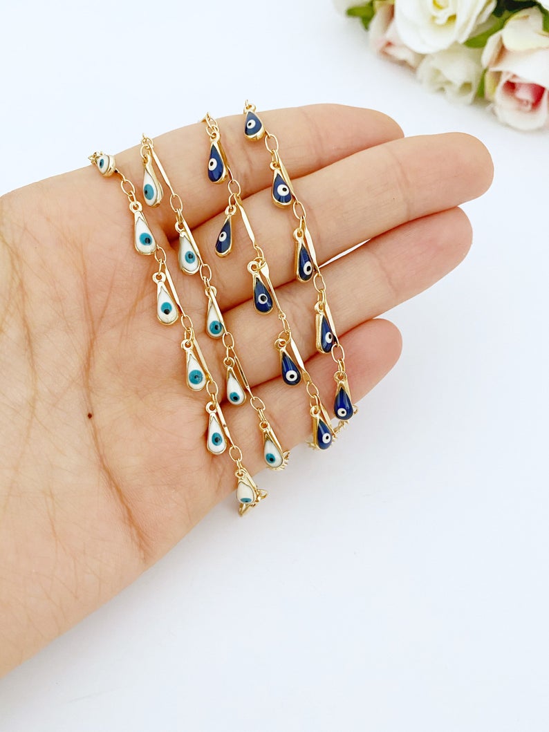 A beautiful Evil Eye Bracelet featuring teardrop blue and white beads on a gold chain, symbolizing protection and style.