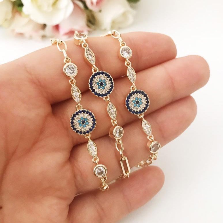 Elegant Evil Eye Bracelet featuring a zircon charm on a gold chain, showcasing a blue evil eye bead.