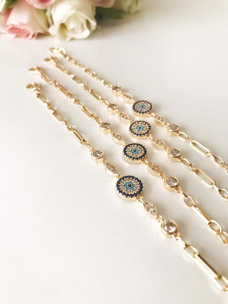 Elegant Evil Eye Bracelet featuring a zircon charm on a gold chain, showcasing a blue evil eye bead.