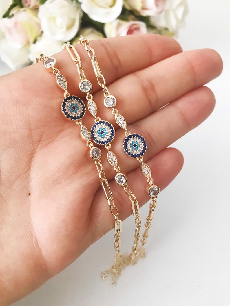 Elegant Evil Eye Bracelet featuring a zircon charm on a gold chain, showcasing a blue evil eye bead.