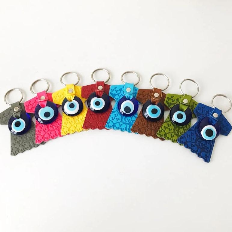 Evil eye caftan keychain featuring a suede leather tulip shape and a glass evil eye bead, available in various colors.