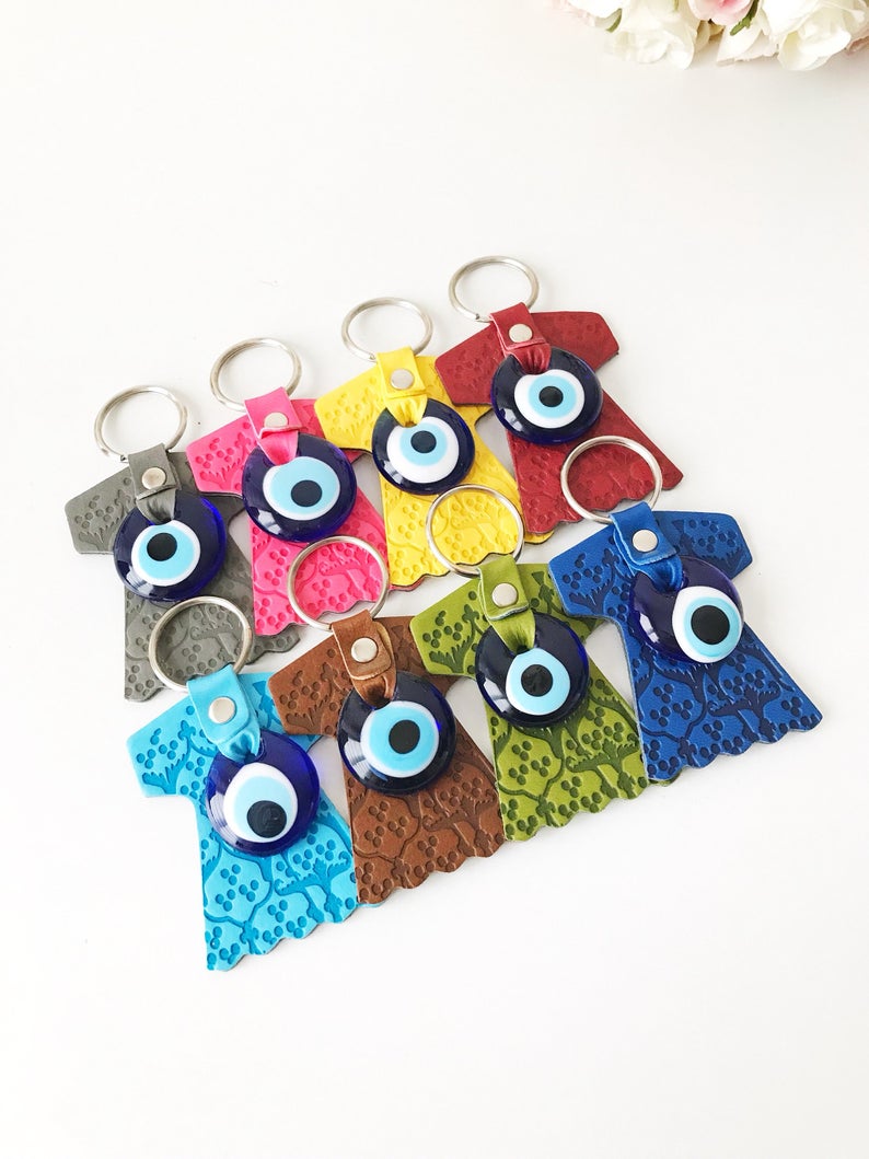 Evil eye caftan keychain featuring a suede leather tulip shape and a glass evil eye bead, available in various colors.