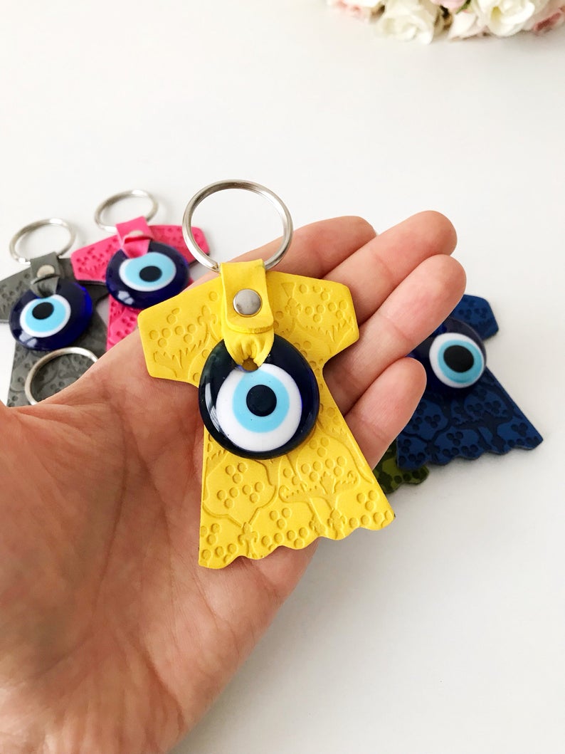 Evil eye caftan keychain featuring a suede leather tulip shape and a glass evil eye bead, available in various colors.