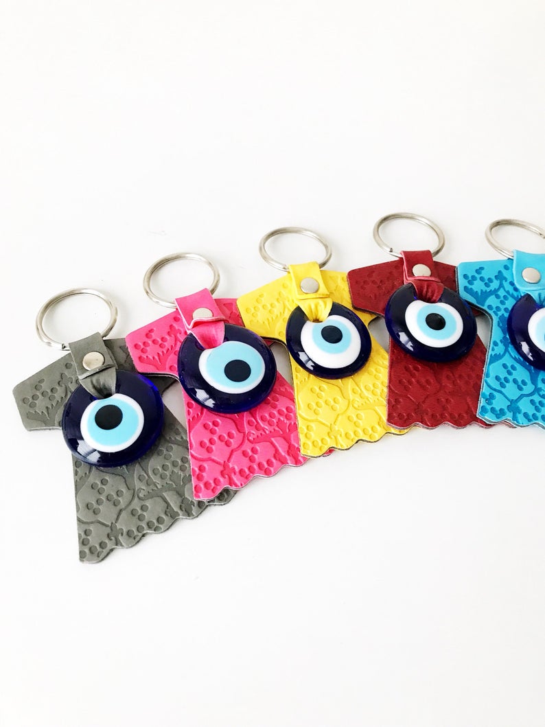 Evil eye caftan keychain featuring a suede leather tulip shape and a glass evil eye bead, available in various colors.