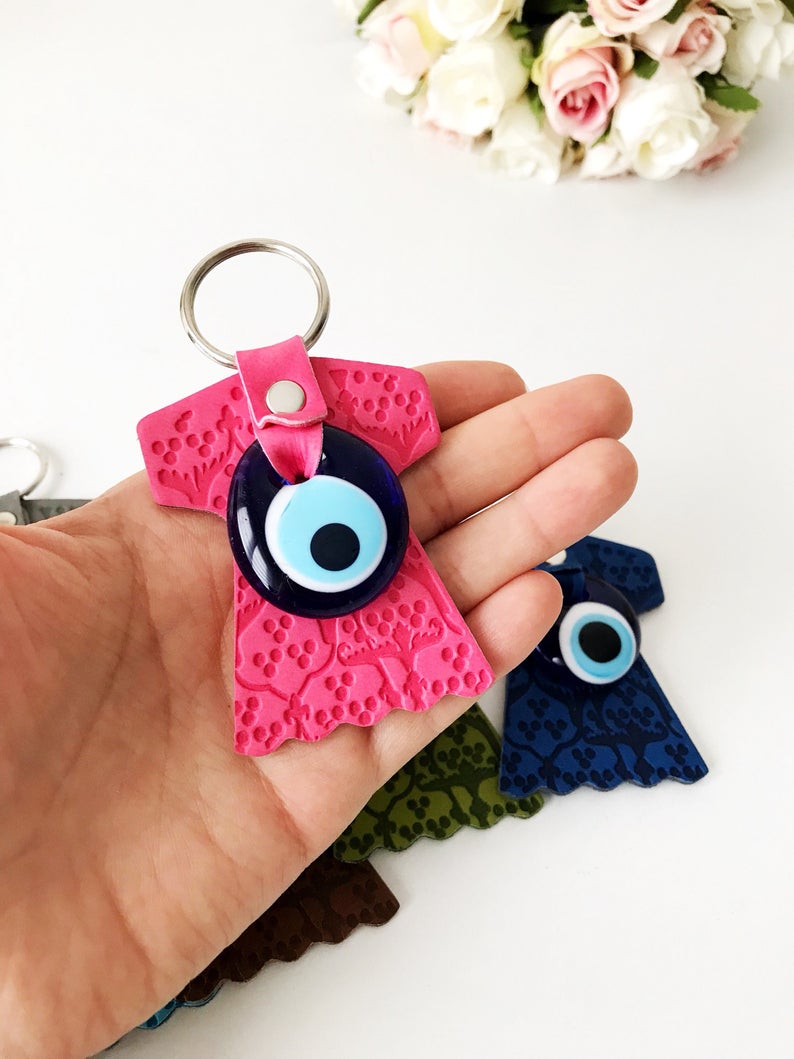 Evil eye caftan keychain featuring a suede leather tulip shape and a glass evil eye bead, available in various colors.