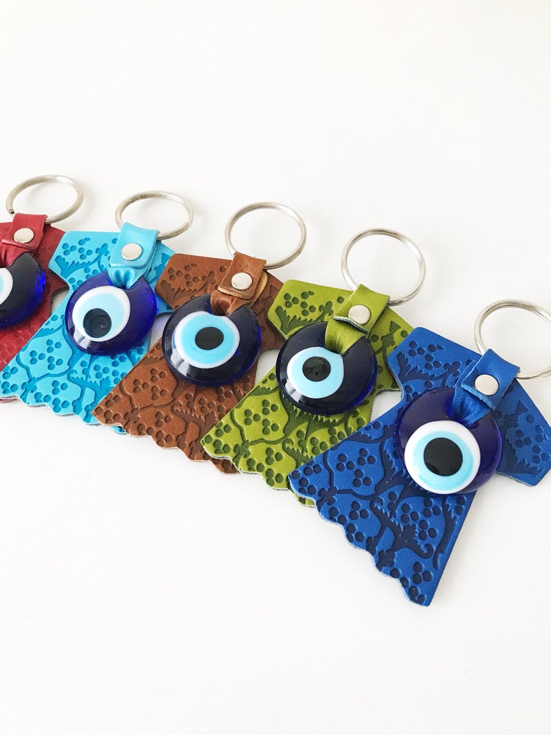 Evil eye caftan keychain featuring a suede leather tulip shape and a glass evil eye bead, available in various colors.