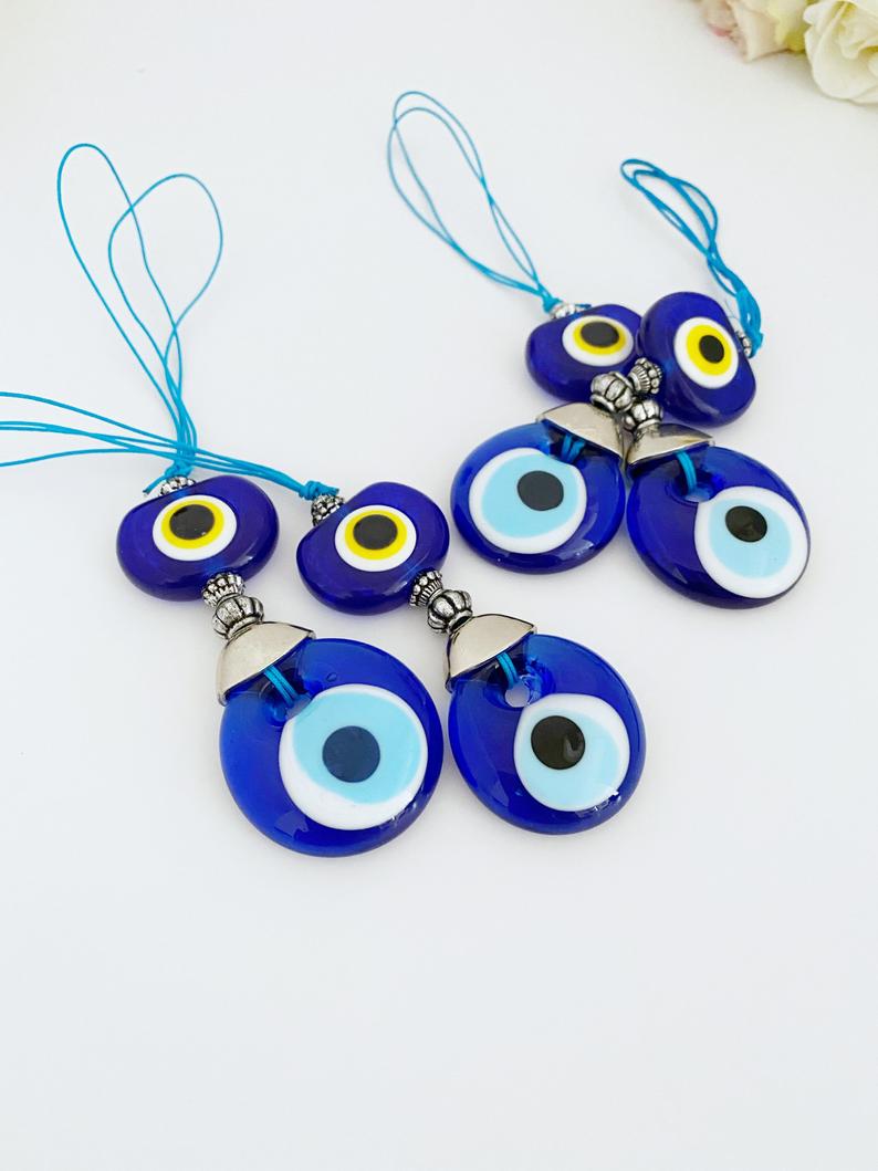 A beautiful blue glass evil eye bead car accessory, featuring a protective charm hanging from a rearview mirror, perfect for gifting and decoration.