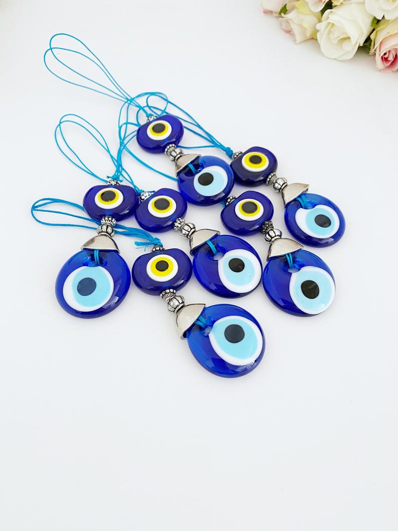 A beautiful blue glass evil eye bead car accessory, featuring a protective charm hanging from a rearview mirror, perfect for gifting and decoration.