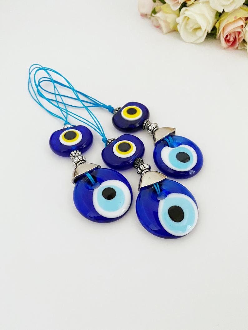 A beautiful blue glass evil eye bead car accessory, featuring a protective charm hanging from a rearview mirror, perfect for gifting and decoration.