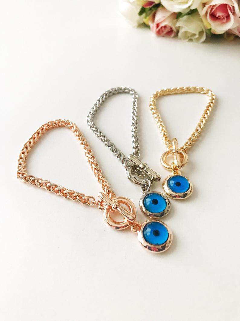 Elegant Evil Eye Chain Bracelet in rose gold, silver, and gold with a blue evil eye bead charm, showcasing its handmade craftsmanship.