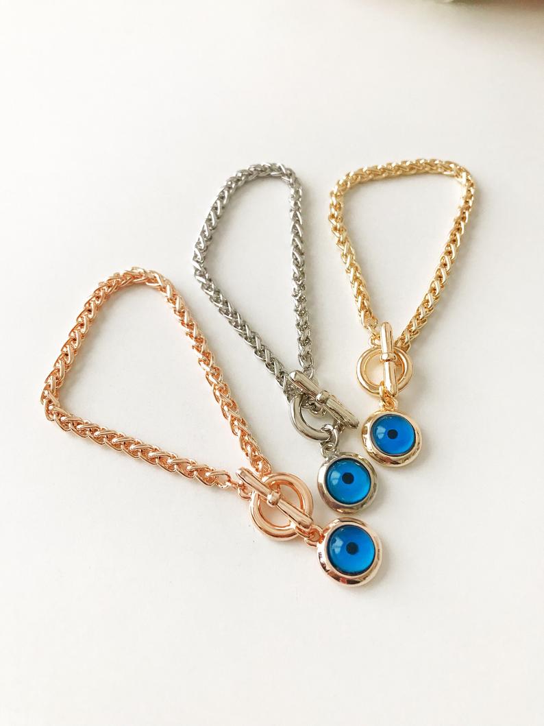 Elegant Evil Eye Chain Bracelet in rose gold, silver, and gold with a blue evil eye bead charm, showcasing its handmade craftsmanship.