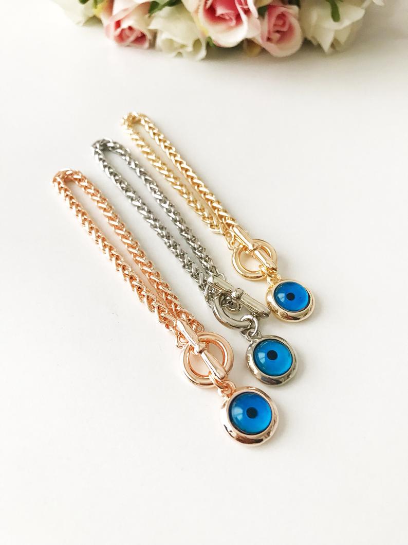 Elegant Evil Eye Chain Bracelet in rose gold, silver, and gold with a blue evil eye bead charm, showcasing its handmade craftsmanship.