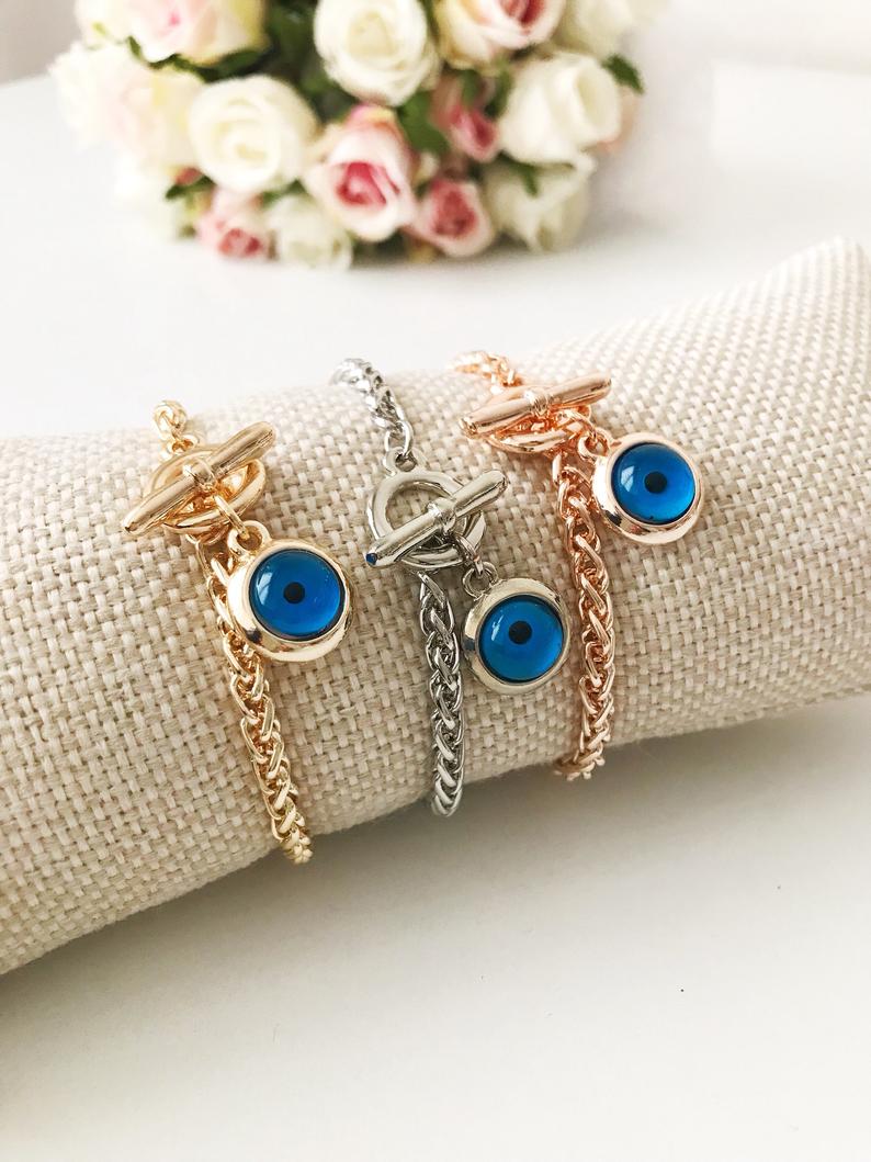 Elegant Evil Eye Chain Bracelet in rose gold, silver, and gold with a blue evil eye bead charm, showcasing its handmade craftsmanship.