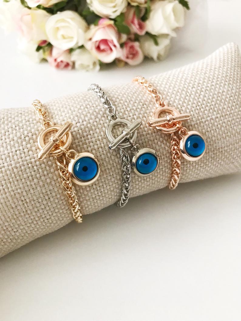 Elegant Evil Eye Chain Bracelet in rose gold, silver, and gold with a blue evil eye bead charm, showcasing its handmade craftsmanship.