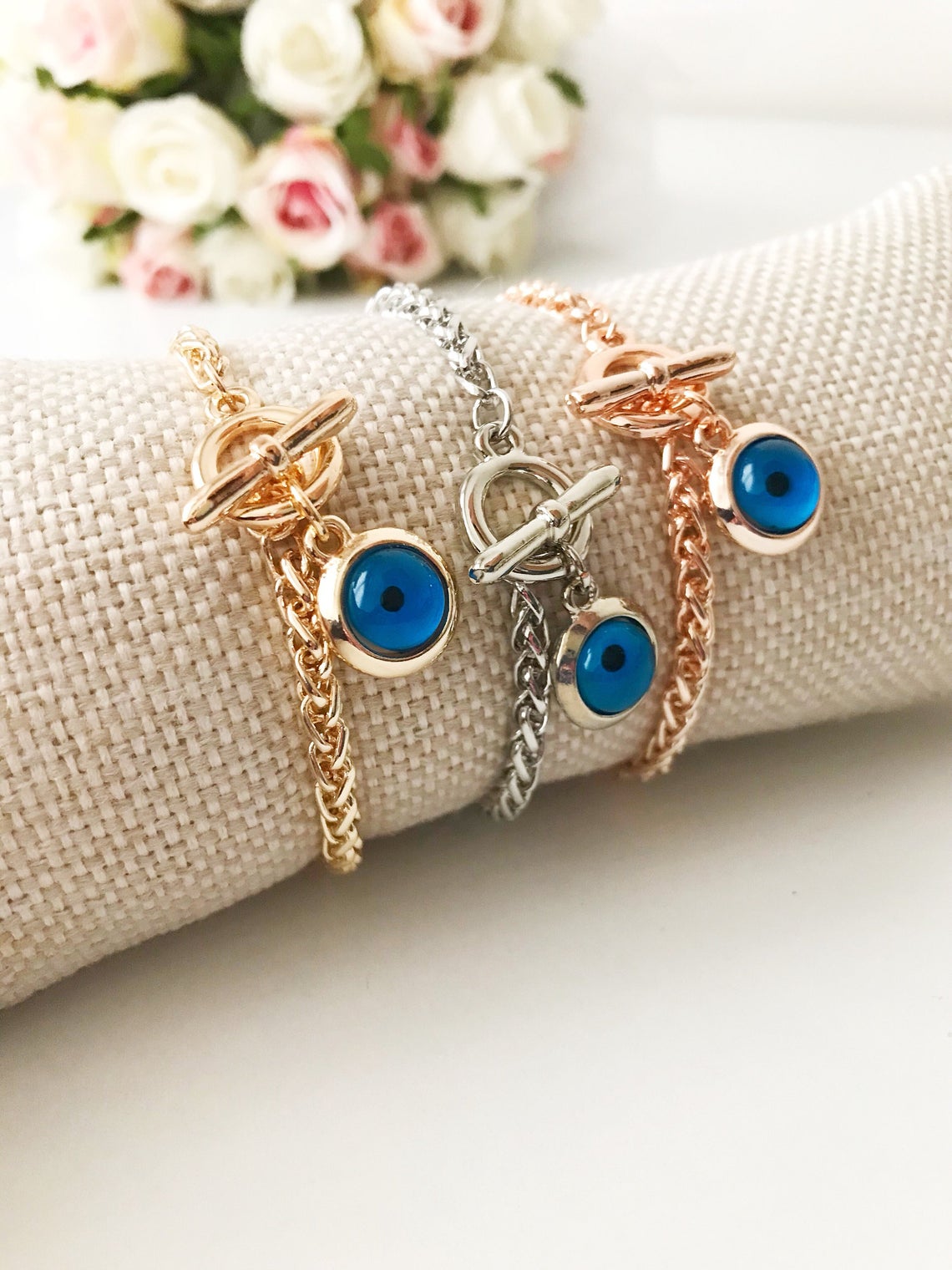 Elegant Evil Eye Chain Bracelet in rose gold, silver, and gold with a blue evil eye bead charm, showcasing its handmade craftsmanship.