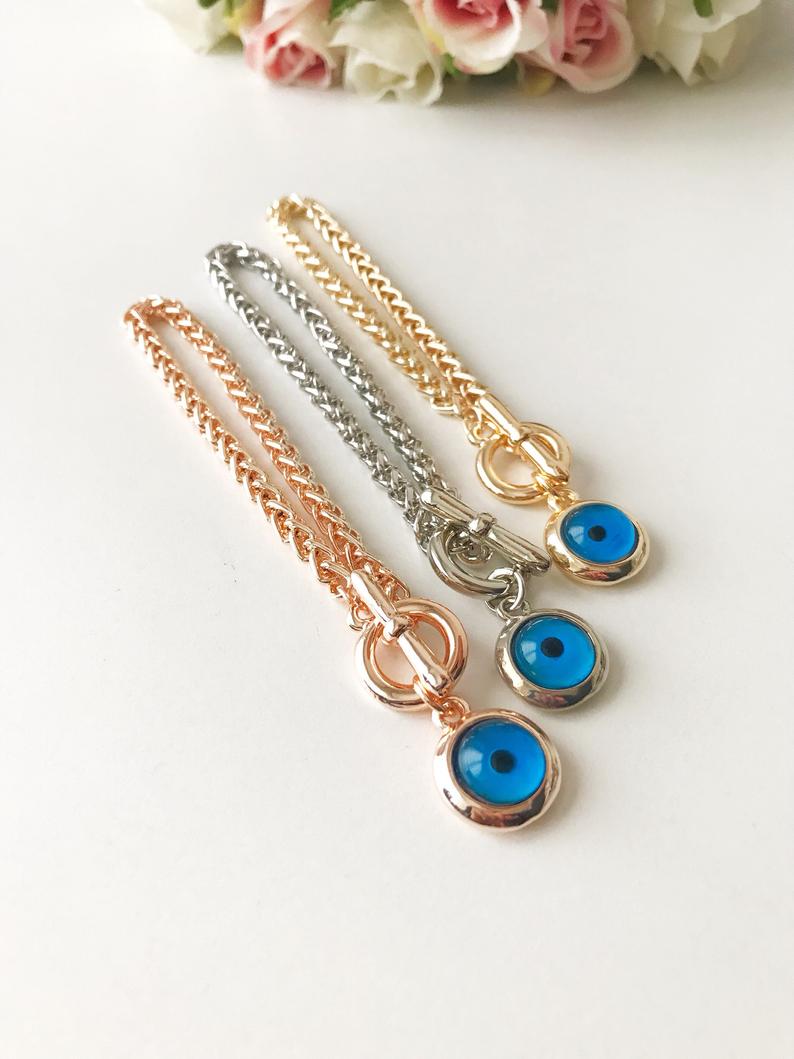 Elegant Evil Eye Chain Bracelet in rose gold, silver, and gold with a blue evil eye bead charm, showcasing its handmade craftsmanship.