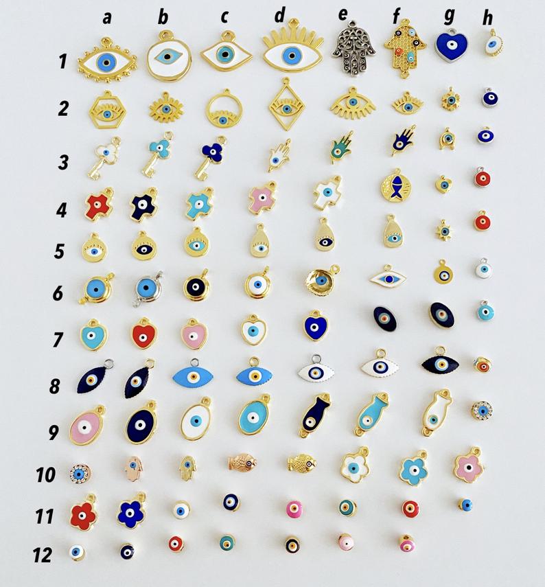 A collection of brass evil eye charms in various styles, showcasing blue and colorful designs for jewelry making.