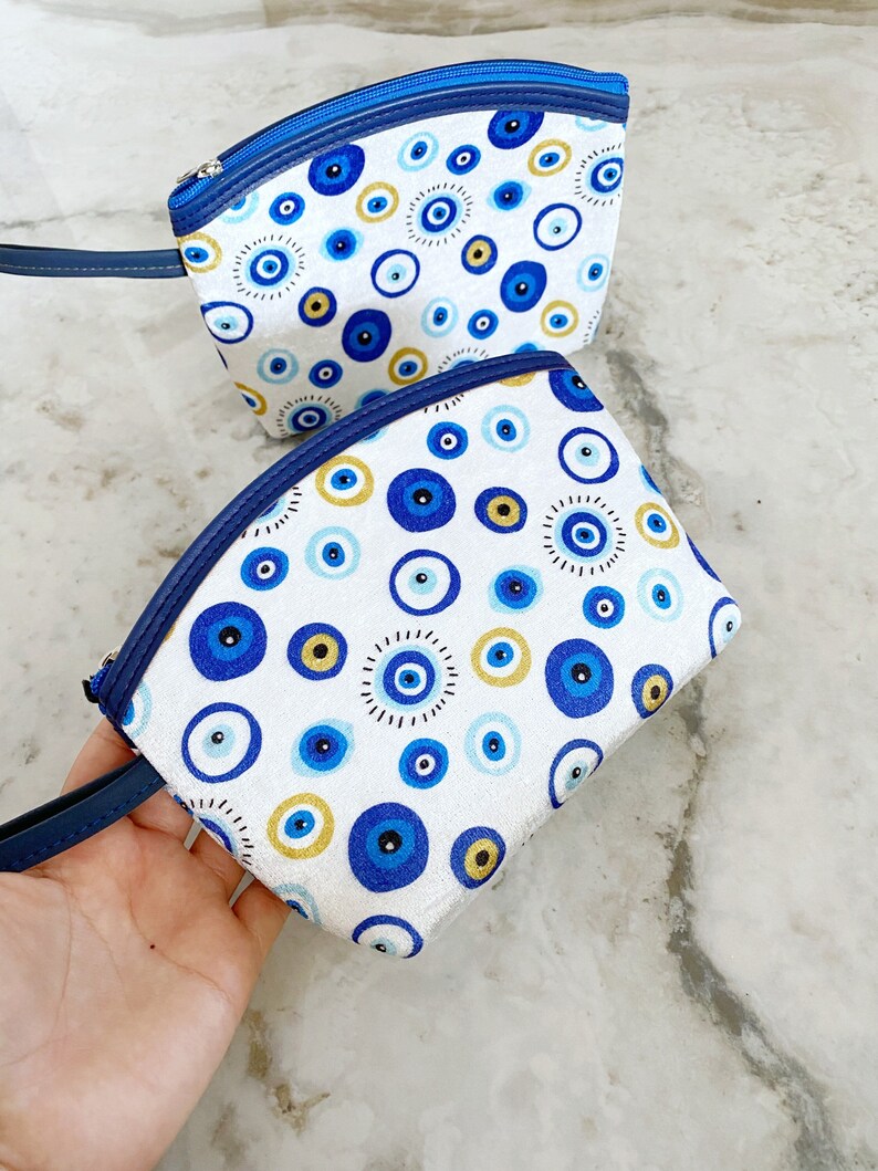 A stylish white Evil Eye Clutch Bag featuring a unique evil eye design, perfect for makeup, travel, and everyday use.