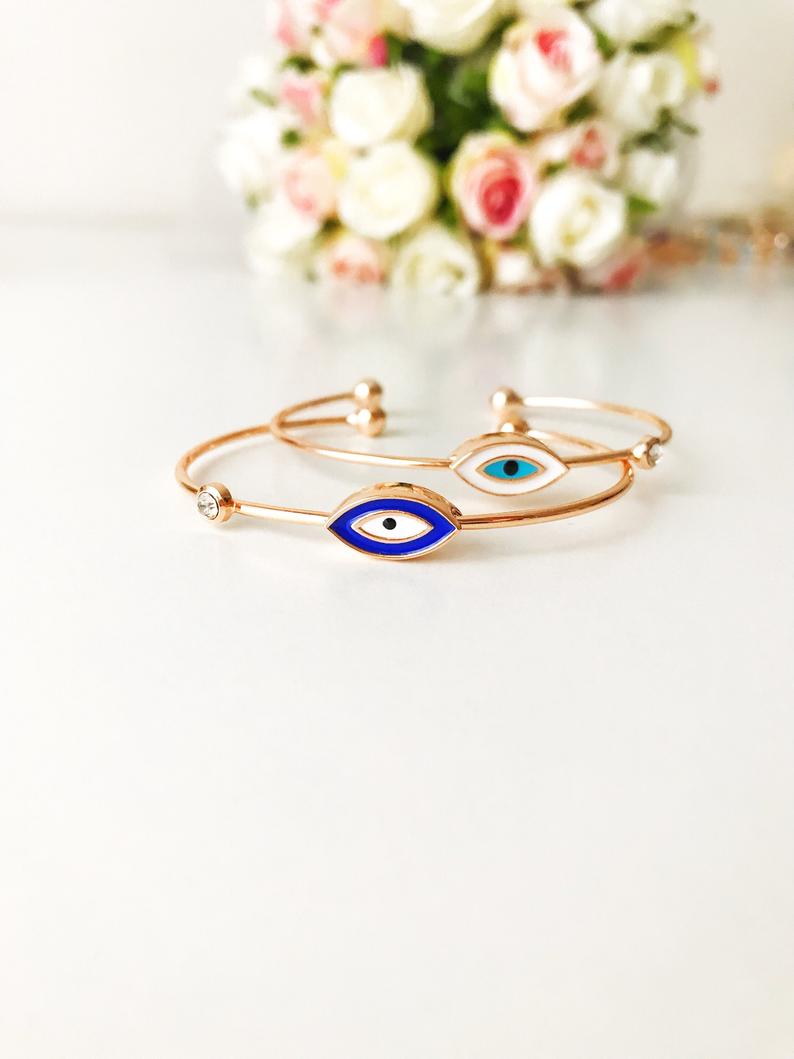 Evil Eye Cuff Bracelet featuring a movable blue and white charm on a rose gold bangle, showcasing its elegant design and adjustable size.