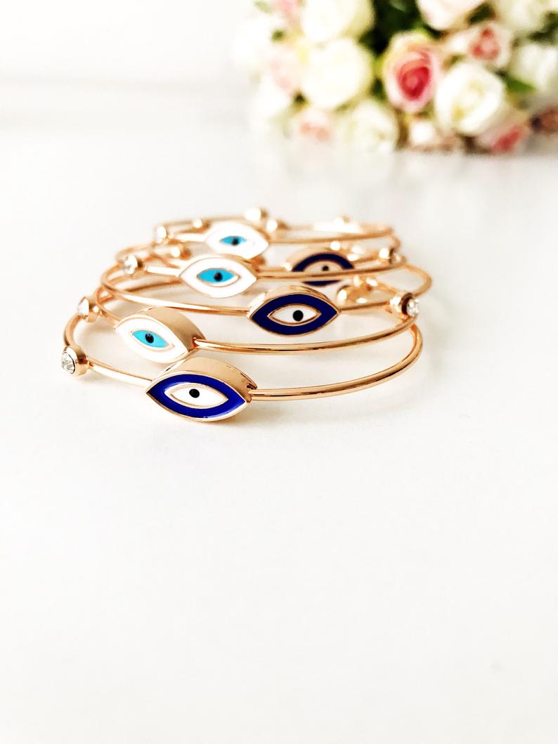 Evil Eye Cuff Bracelet featuring a movable blue and white charm on a rose gold bangle, showcasing its elegant design and adjustable size.