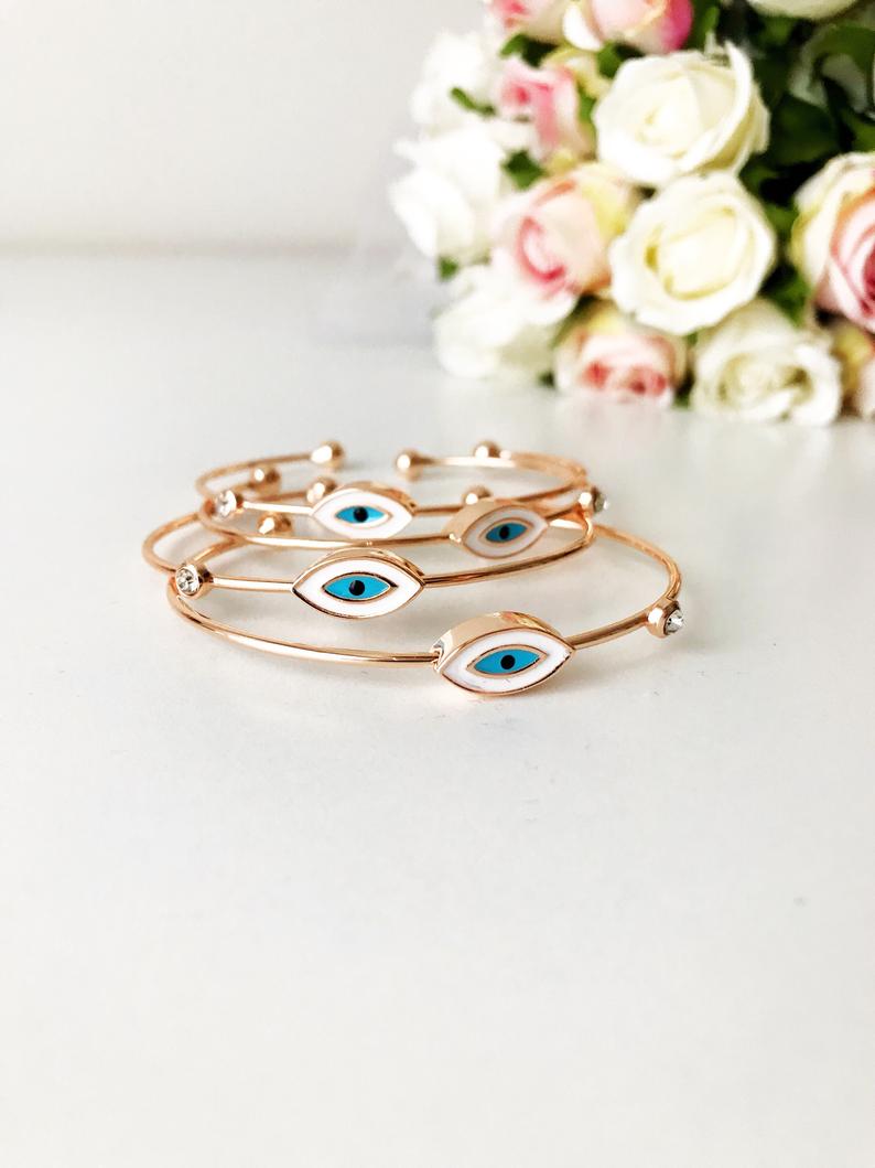 Evil Eye Cuff Bracelet featuring a movable blue and white charm on a rose gold bangle, showcasing its elegant design and adjustable size.