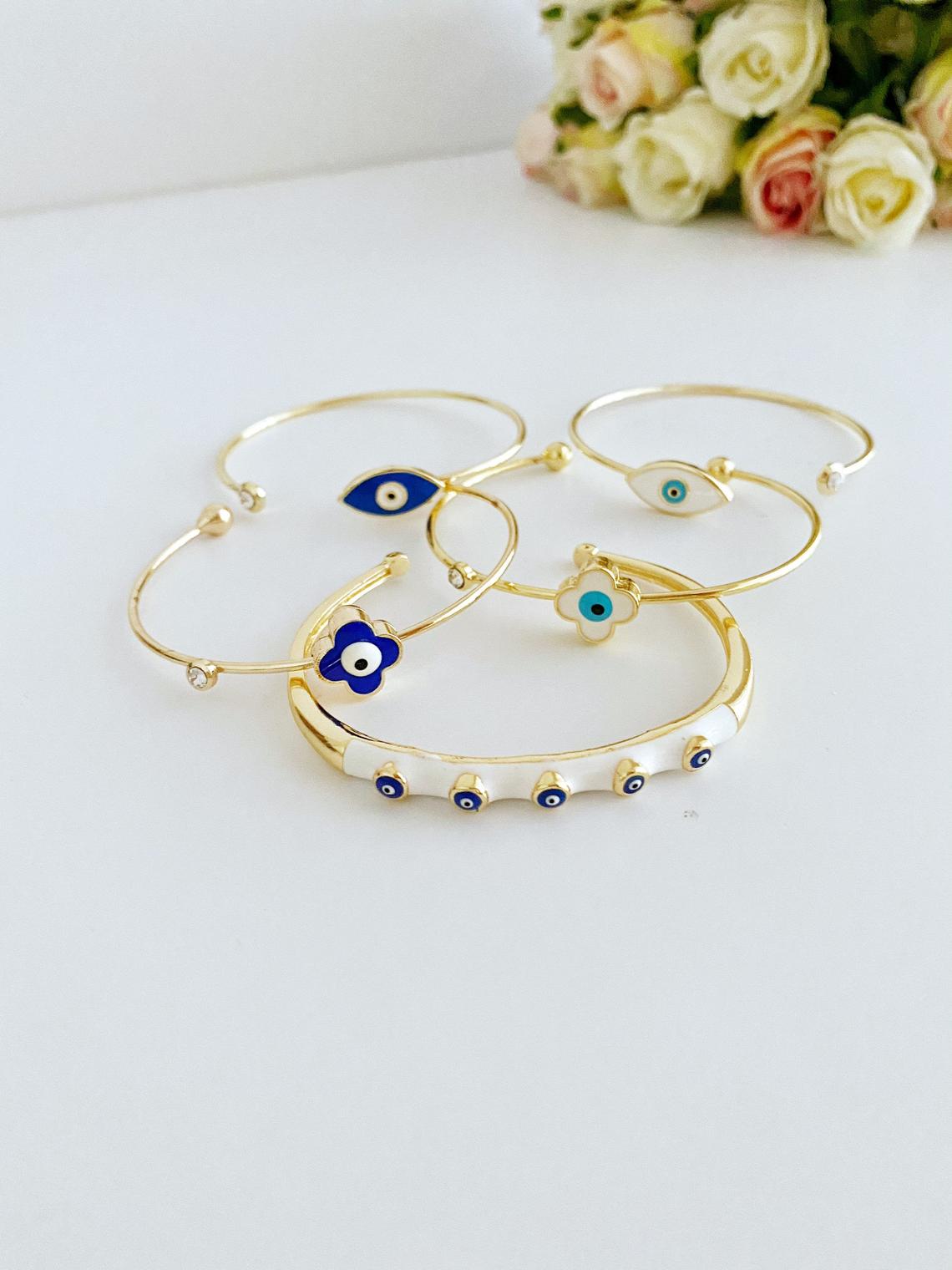 Elegant Evil Eye Cuff Bracelet in gold, featuring a protective blue evil eye bead and stylish design.