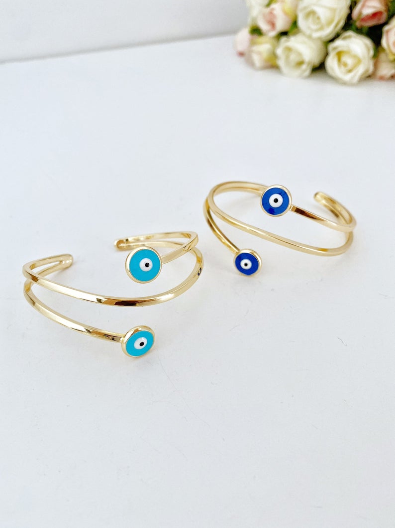 Gold Evil Eye Cuff Bracelet featuring a movable oval charm and adjustable stainless steel design, perfect for stylish protection.