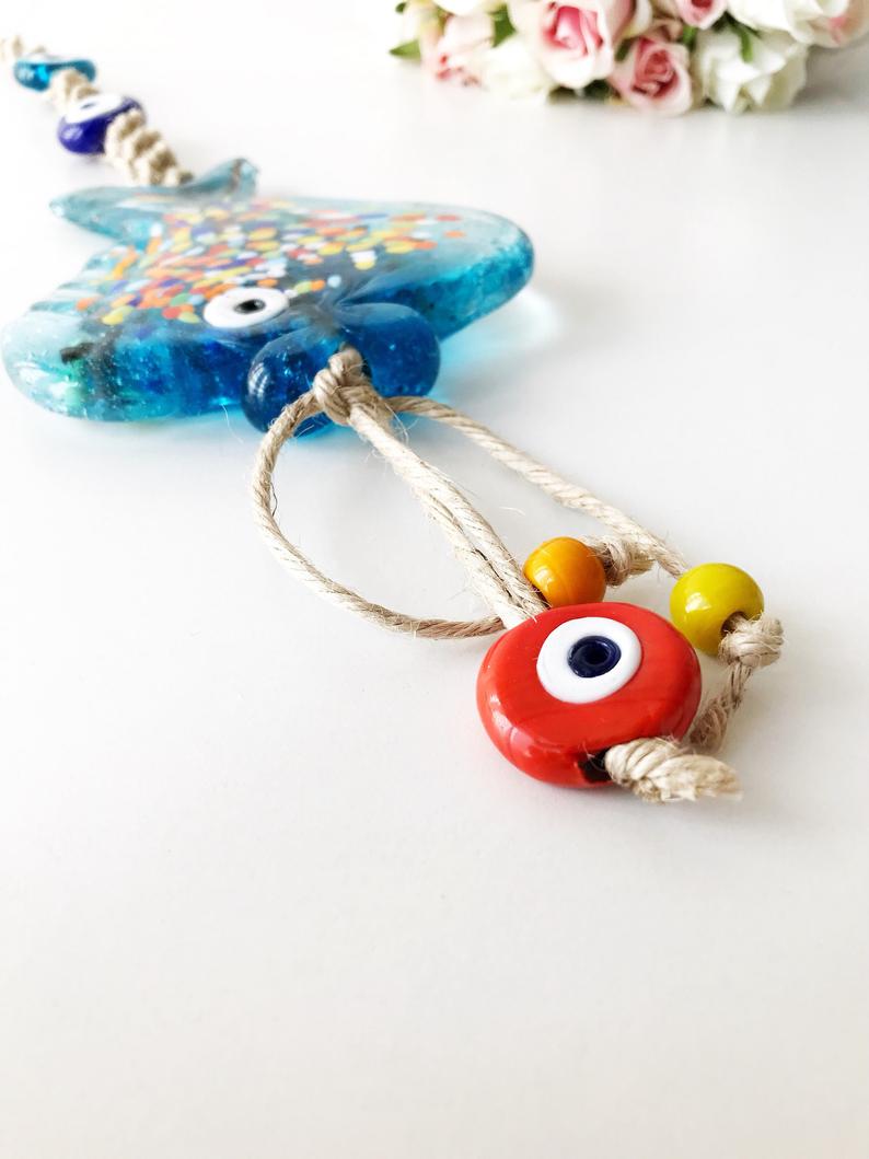 Handmade Evil Eye Fish Wall Hanging featuring vibrant glass fish and evil eye beads in turquoise and dark blue colors.