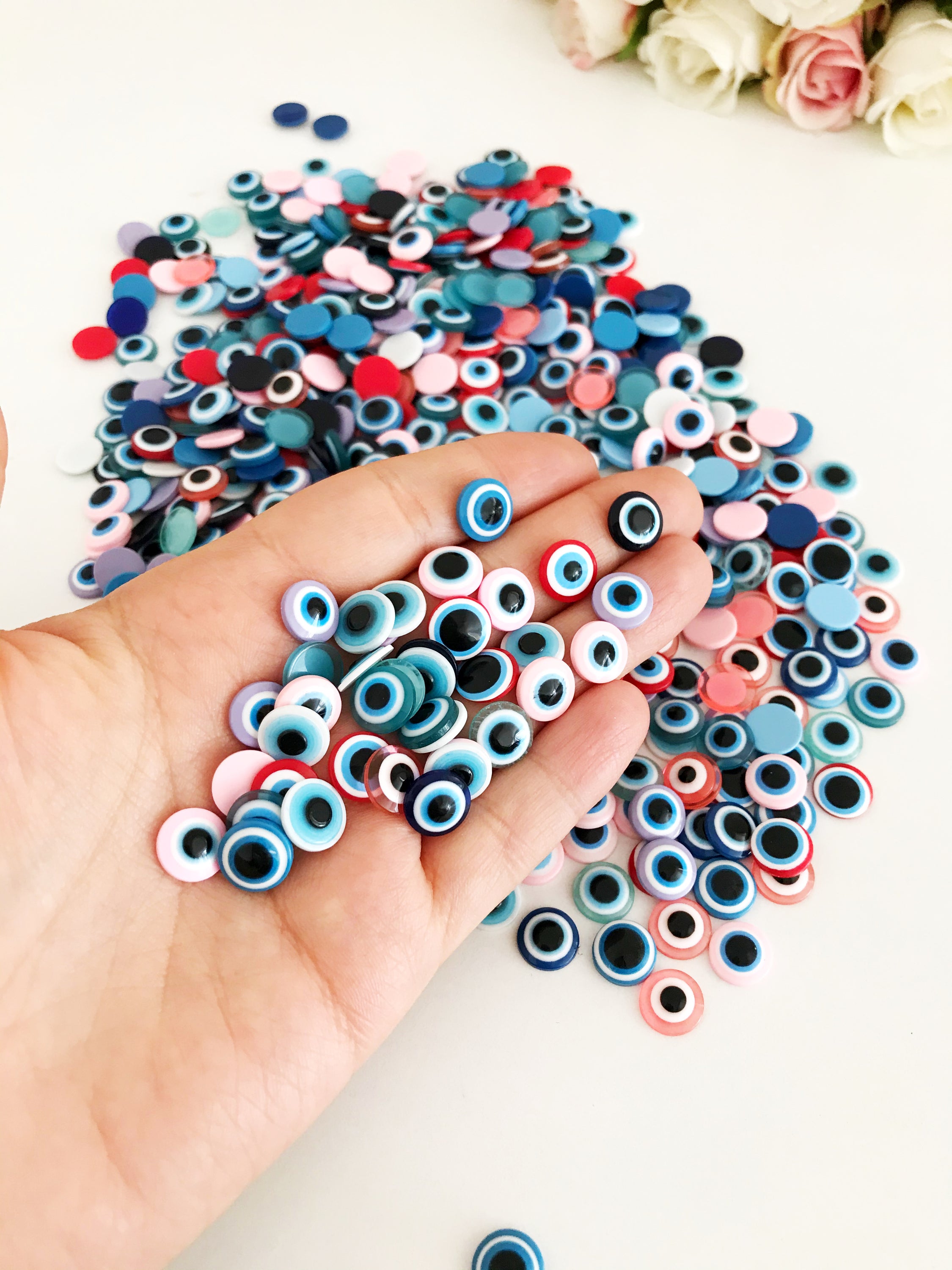 A pack of 20 colorful 10mm evil eye flat back resin cabochons, ideal for jewelry making and crafts.