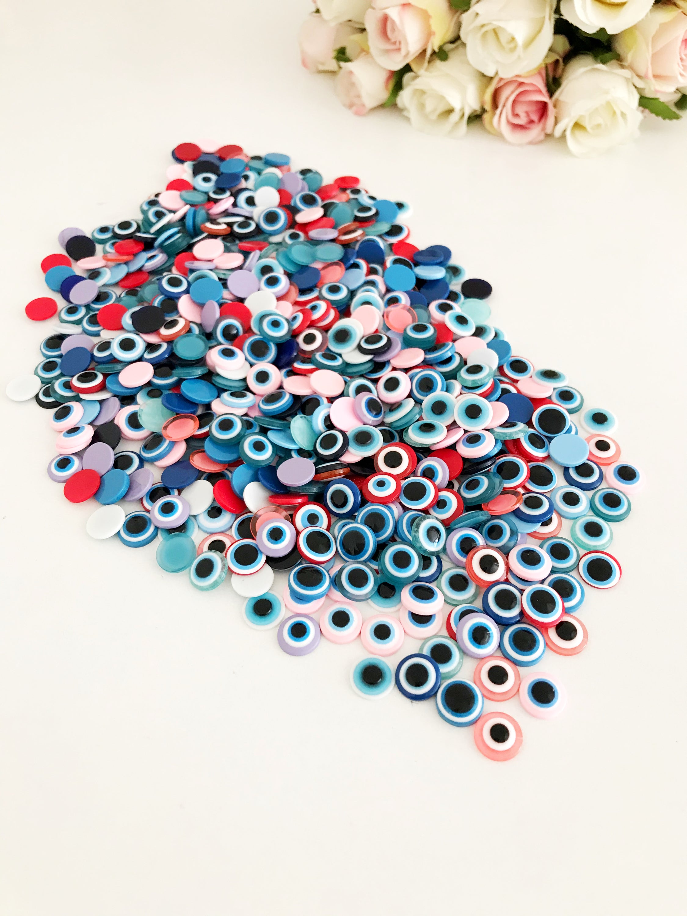 A pack of 20 colorful 10mm evil eye flat back resin cabochons, ideal for jewelry making and crafts.