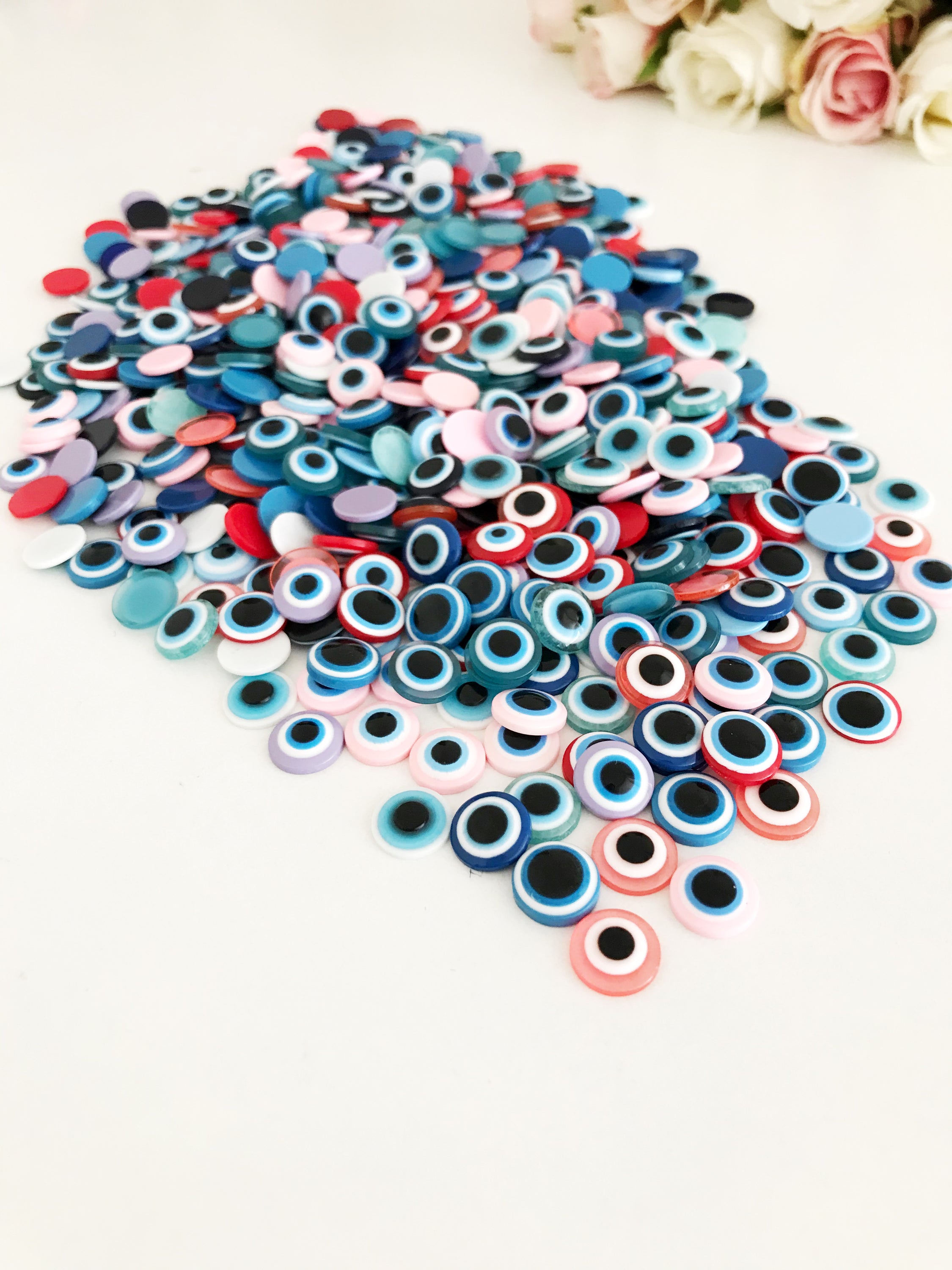 A pack of 20 colorful 10mm evil eye flat back resin cabochons, ideal for jewelry making and crafts.