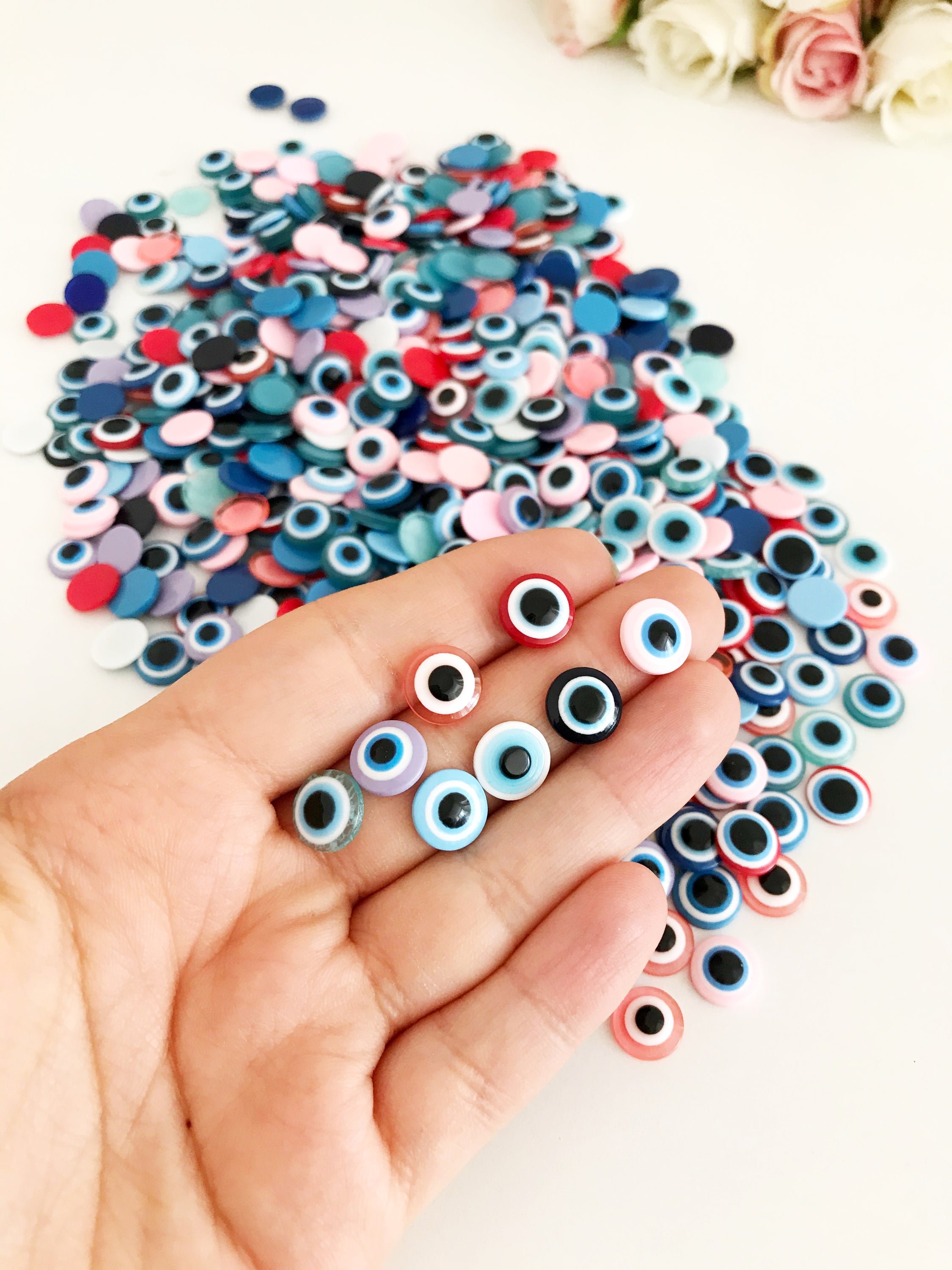 A pack of 20 colorful 10mm evil eye flat back resin cabochons, ideal for jewelry making and crafts.