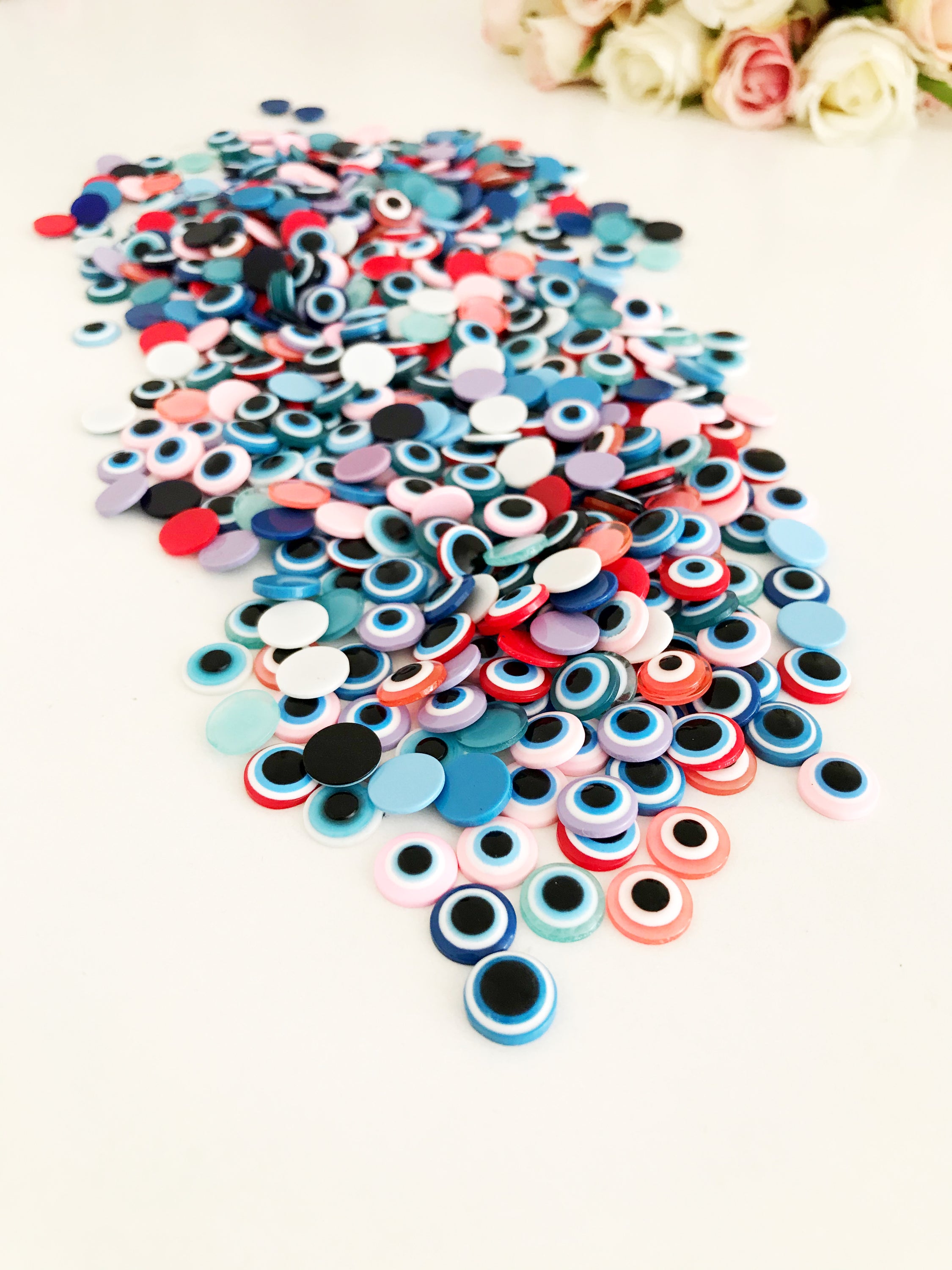 A pack of 20 colorful 10mm evil eye flat back resin cabochons, ideal for jewelry making and crafts.