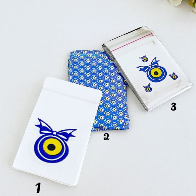 A collection of 100 elegant evil eye gift bags in white, blue, and gray, featuring the traditional Turkish evil eye design.