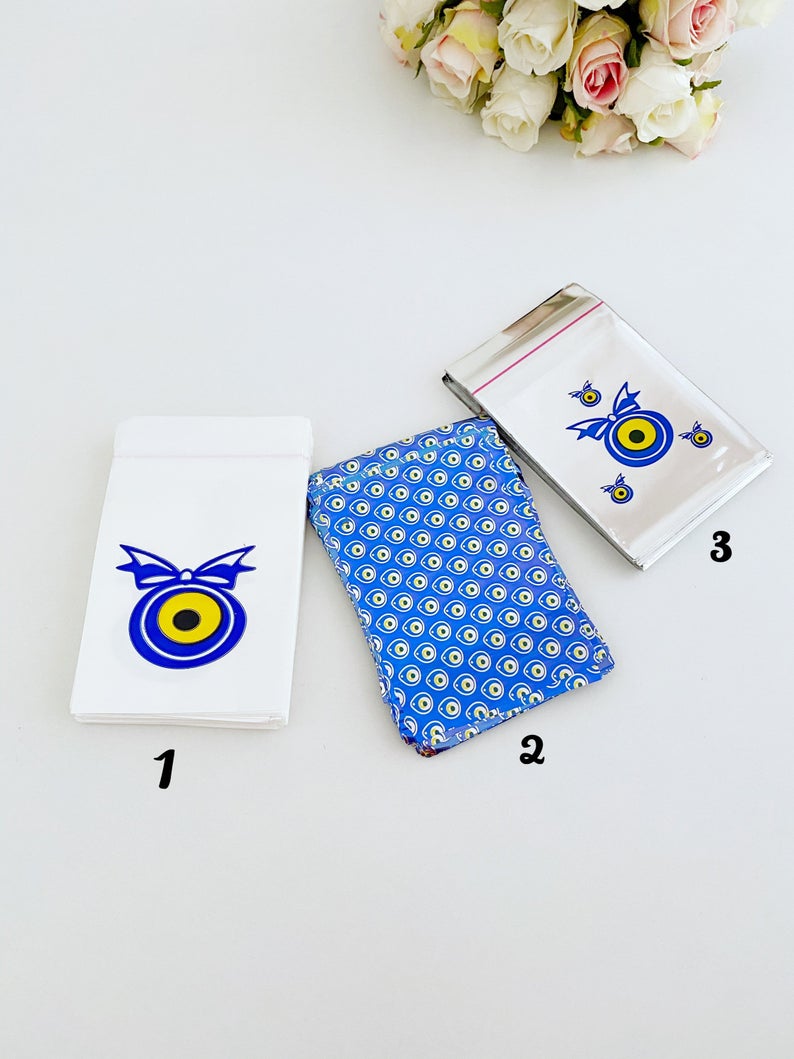 A collection of 100 elegant evil eye gift bags in white, blue, and gray, featuring the traditional Turkish evil eye design.