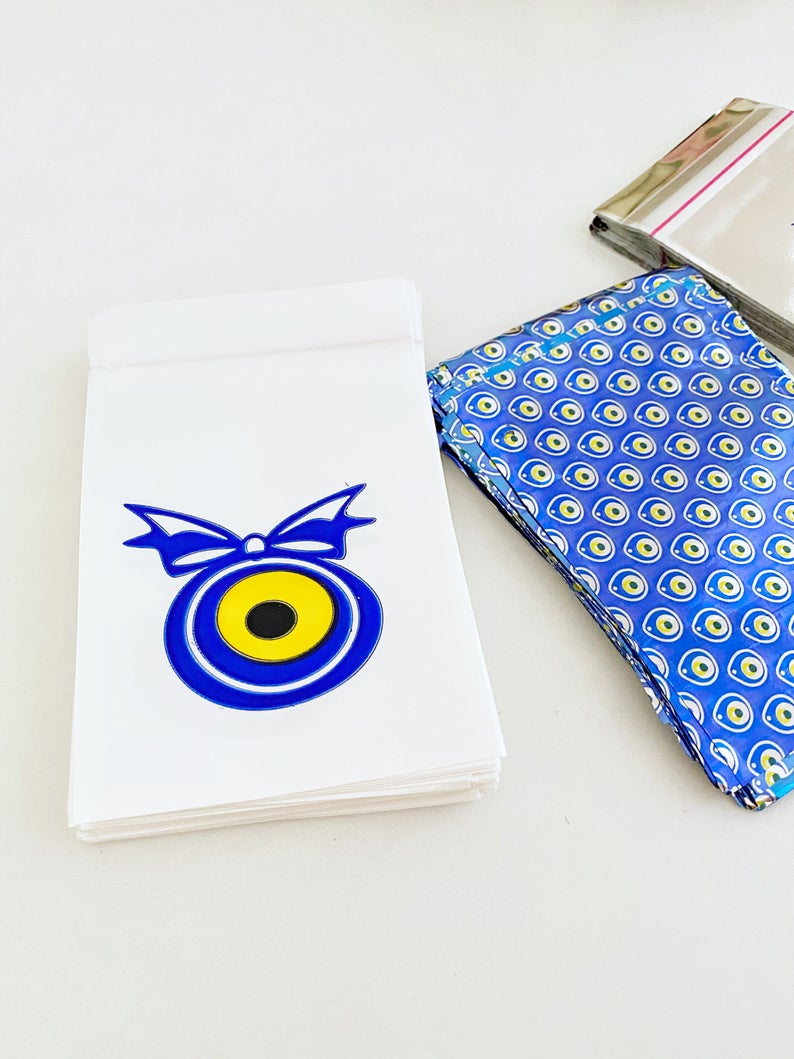 A collection of 100 elegant evil eye gift bags in white, blue, and gray, featuring the traditional Turkish evil eye design.