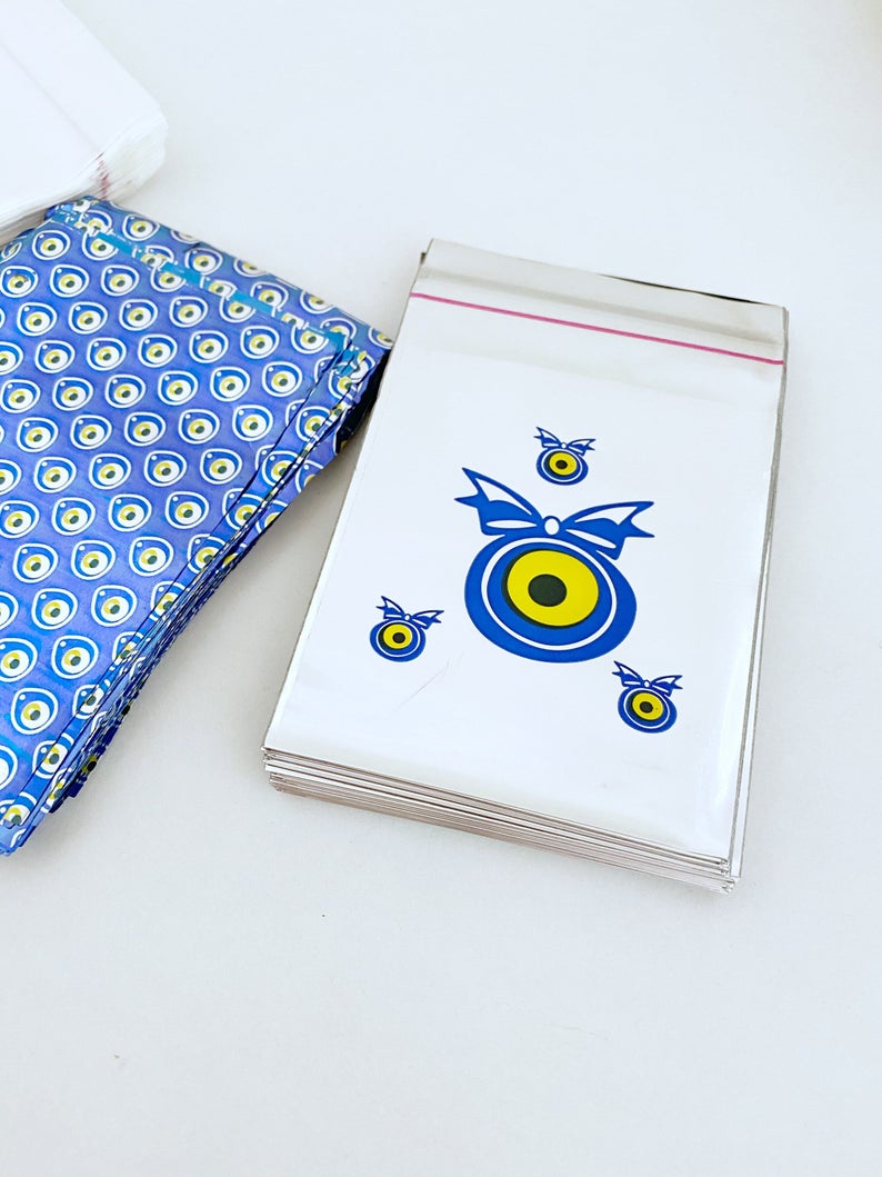 A collection of 100 elegant evil eye gift bags in white, blue, and gray, featuring the traditional Turkish evil eye design.