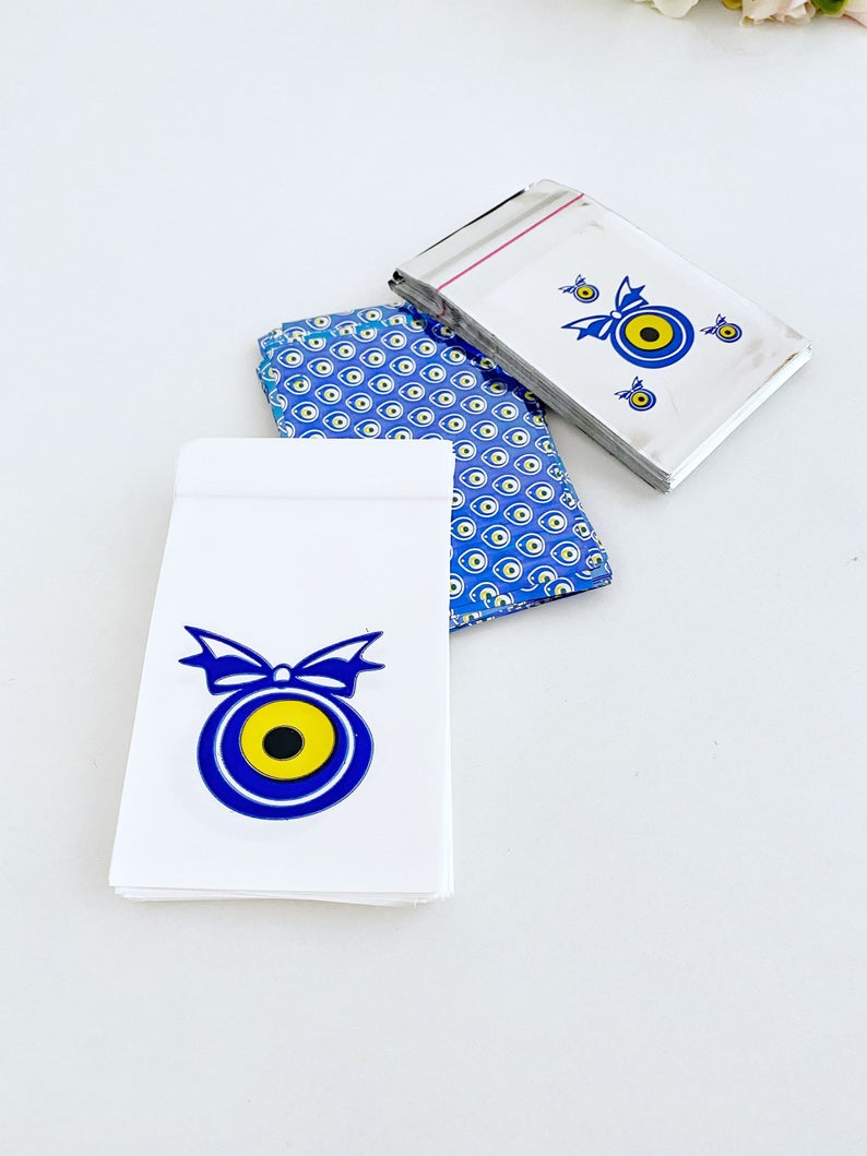 A collection of 100 elegant evil eye gift bags in white, blue, and gray, featuring the traditional Turkish evil eye design.